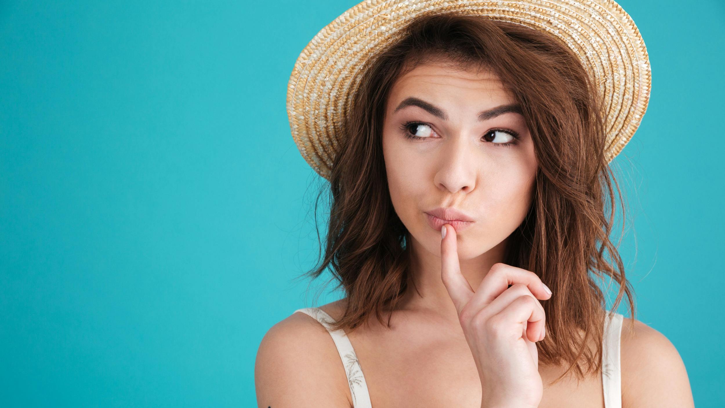 Eftertænksom kvinde med hat