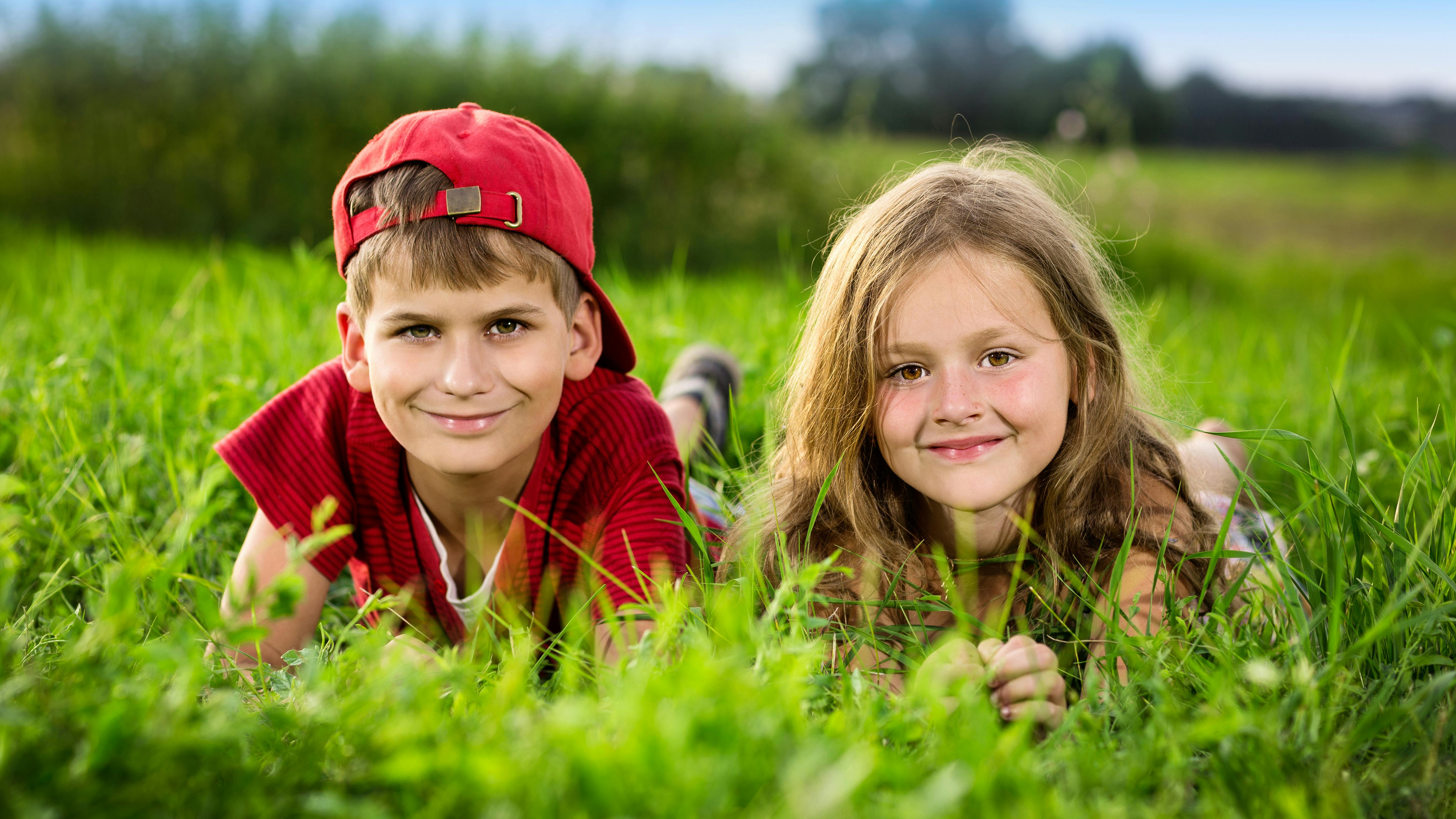 To børn ligger i græsset