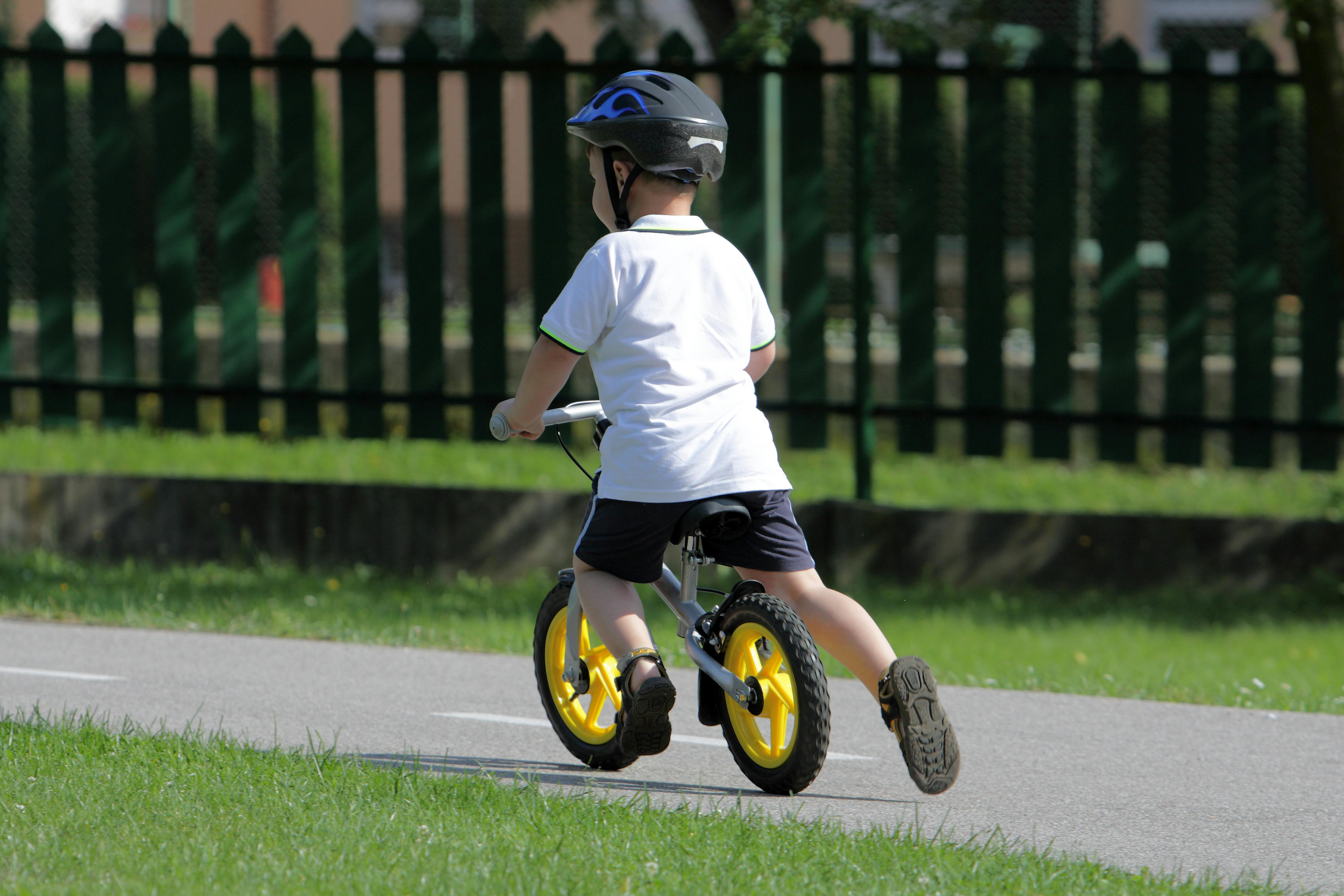 Baby boy on traffic playground for childs with crash helmet