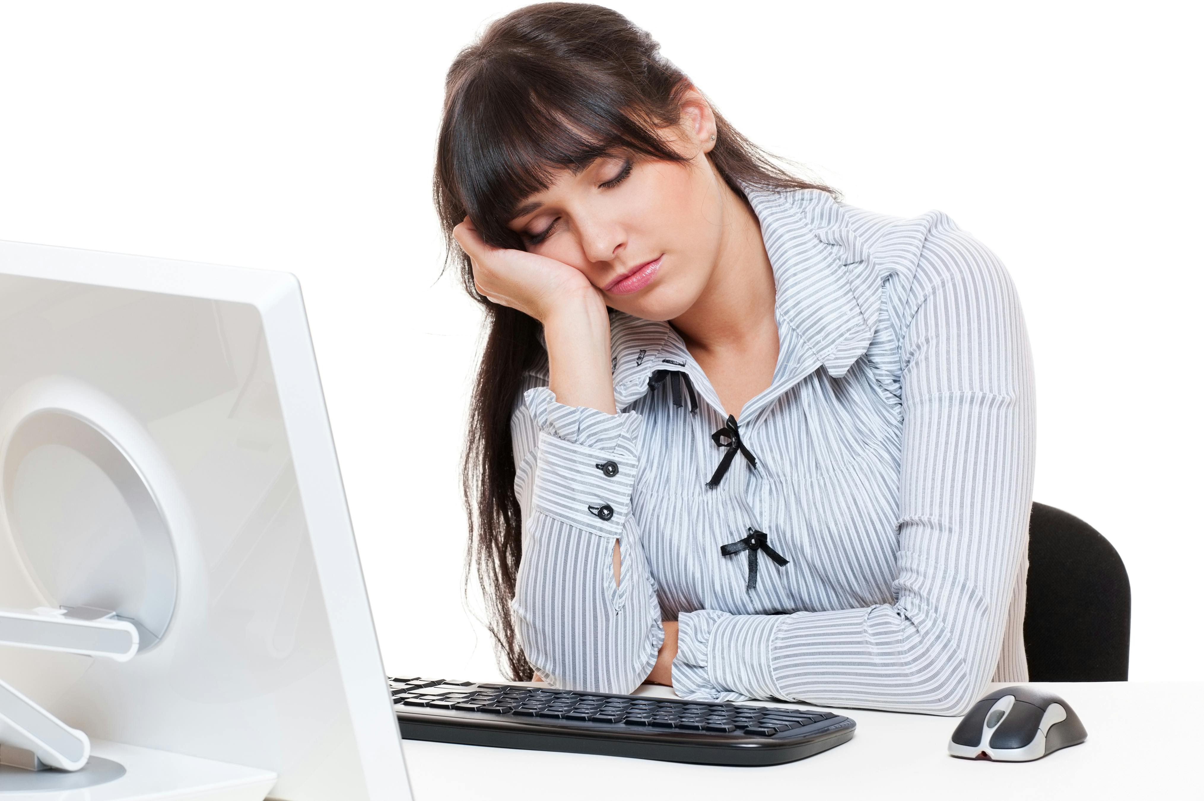 Træt kvinde sover over computeren