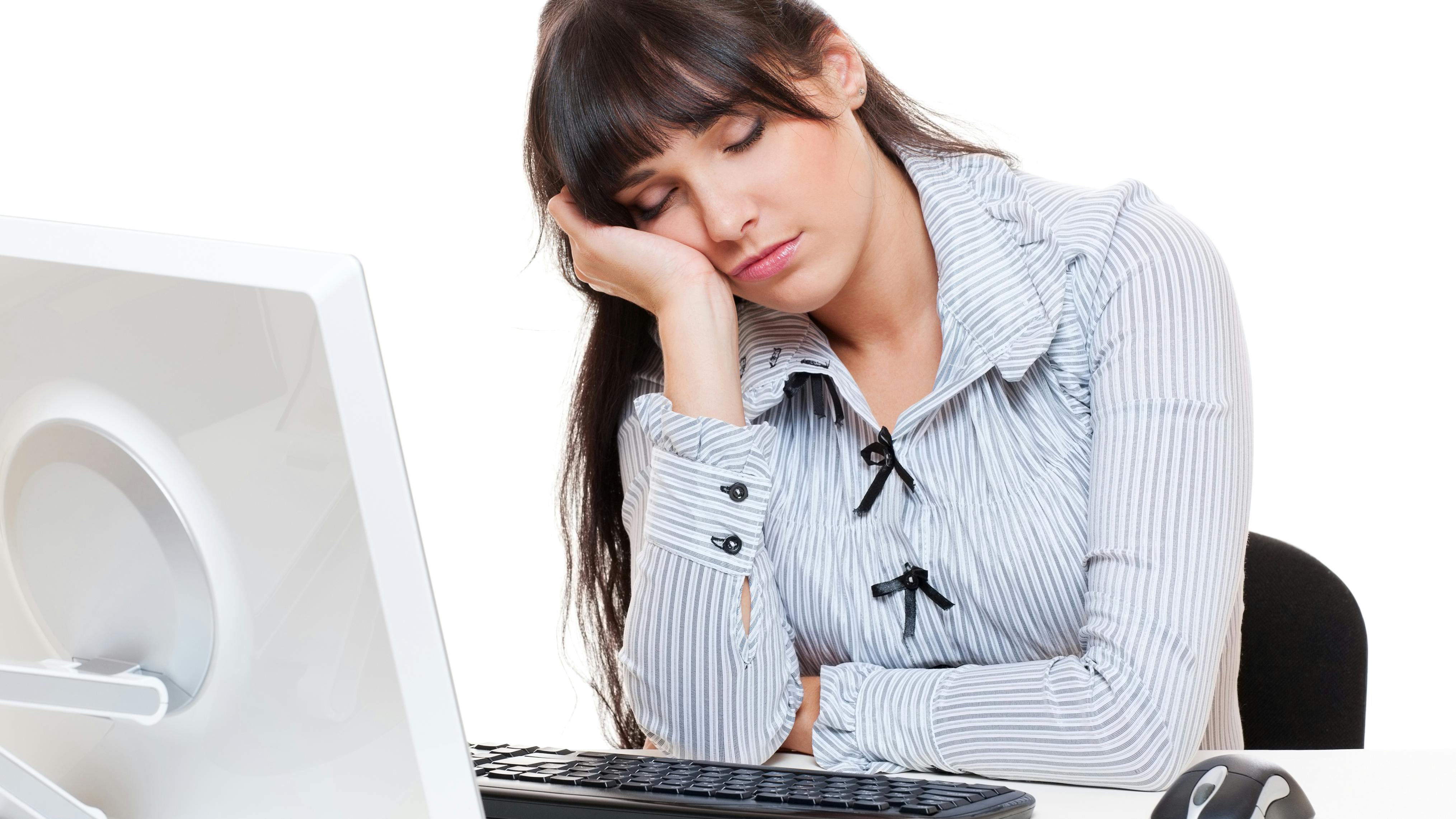 Træt kvinde sover over computeren