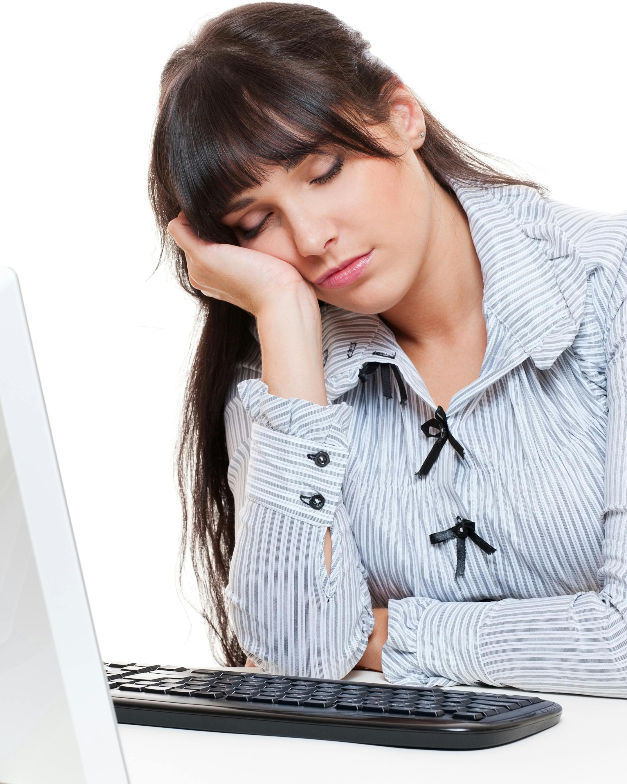 Træt kvinde sover over computeren