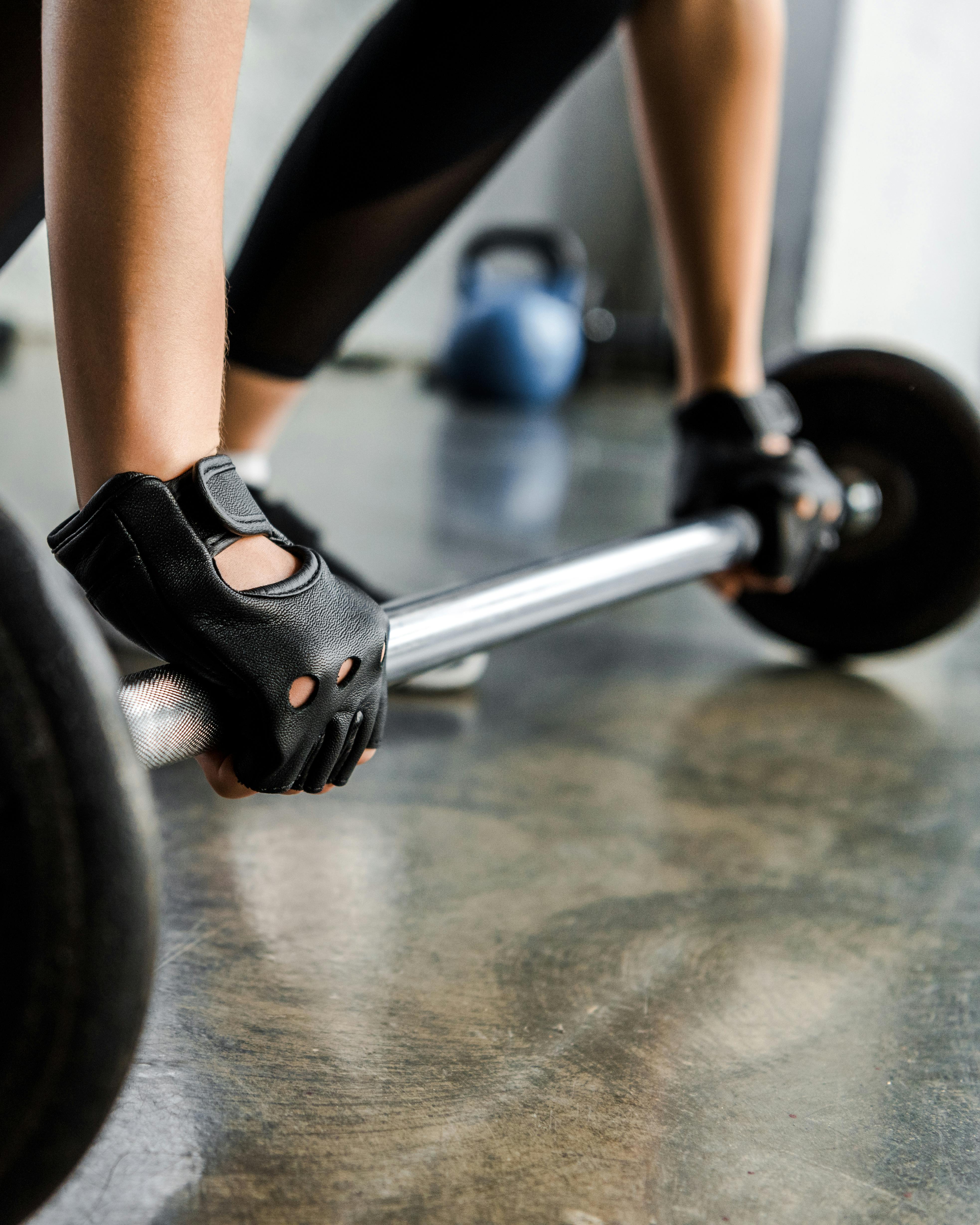 Kvinde løfter vægte i fitnesscenteret