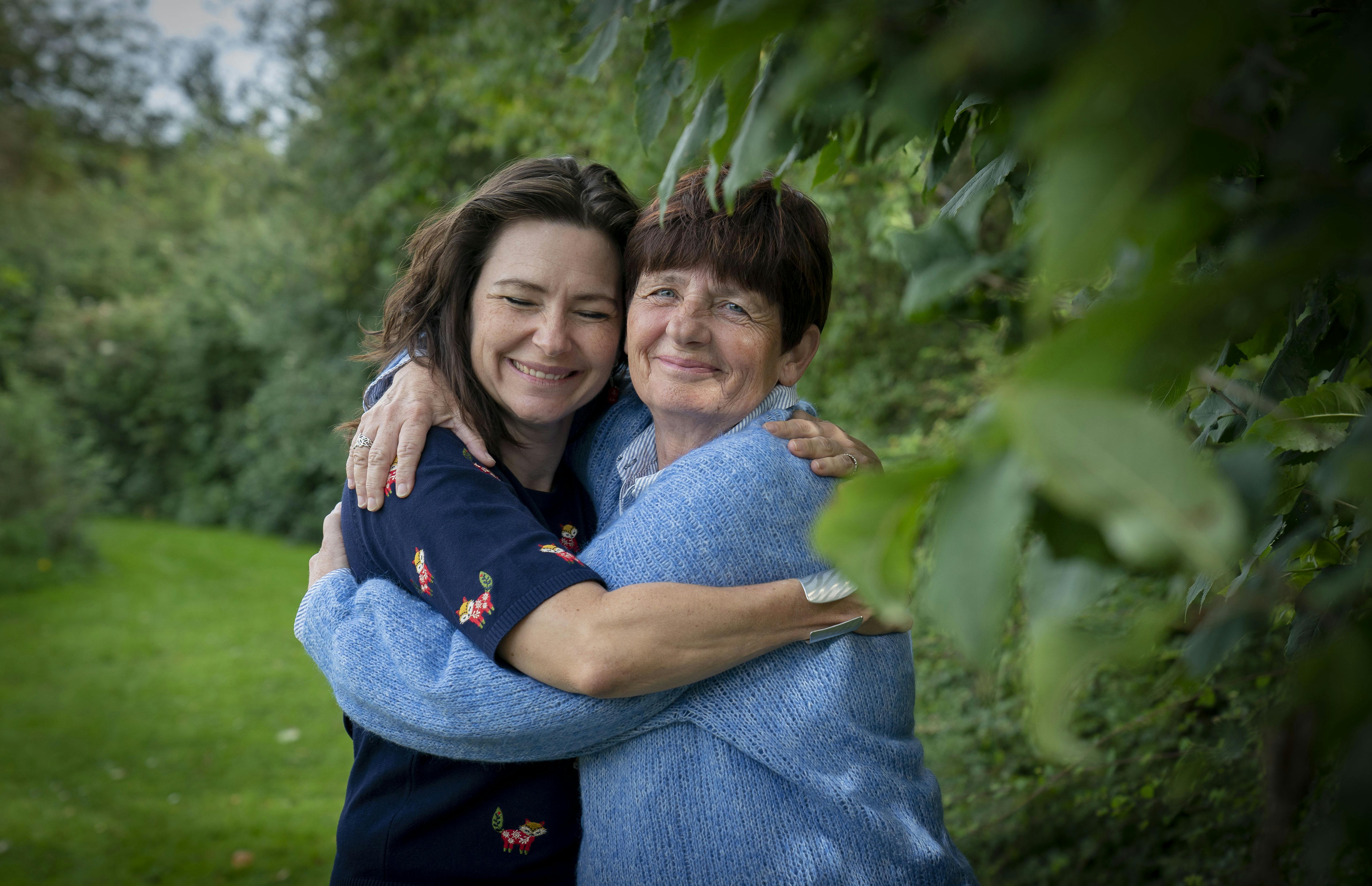 Stinemaria og hendes mor krammer ved en busk