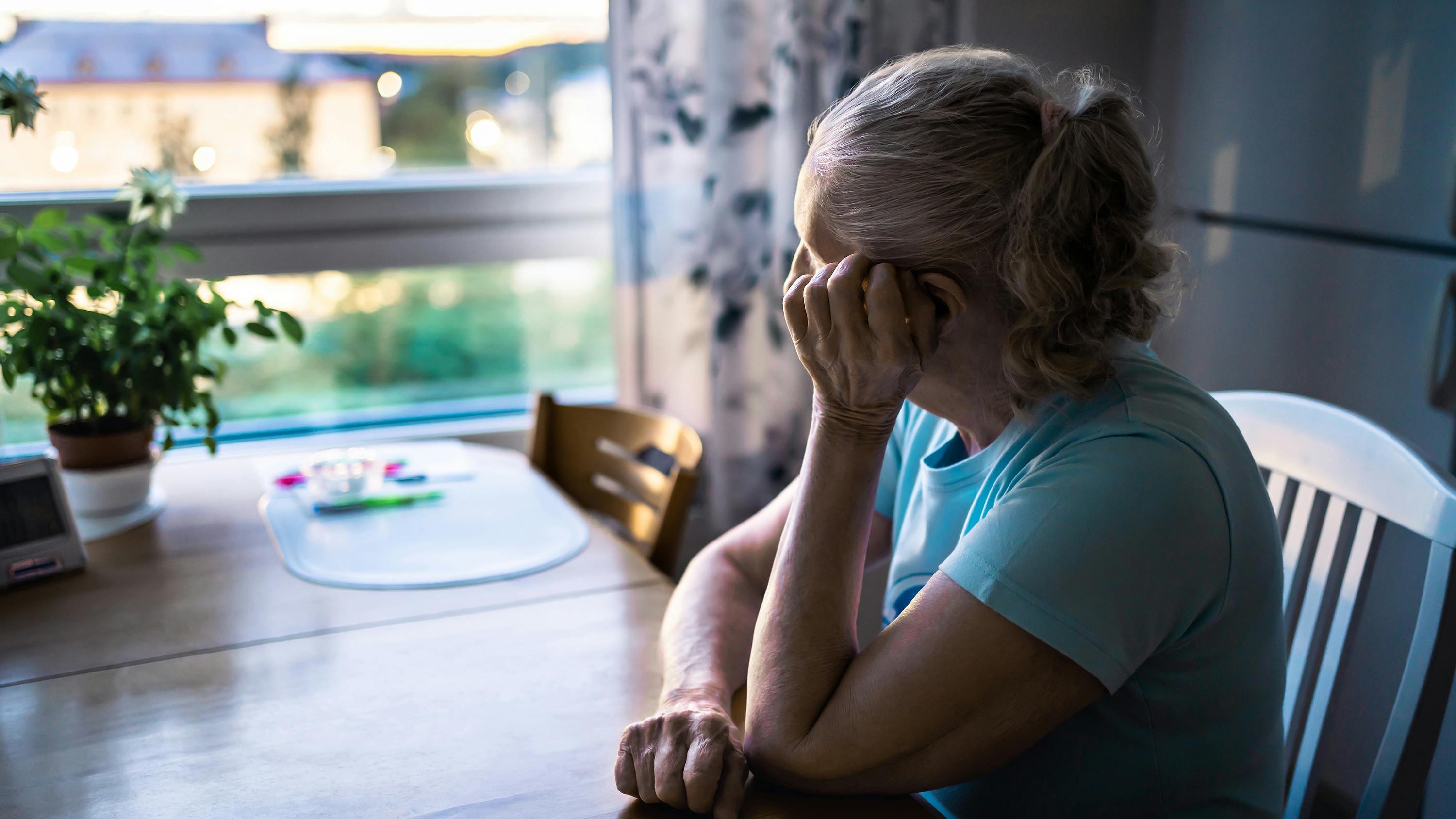 Trist kvinde kigger ud af vinduet