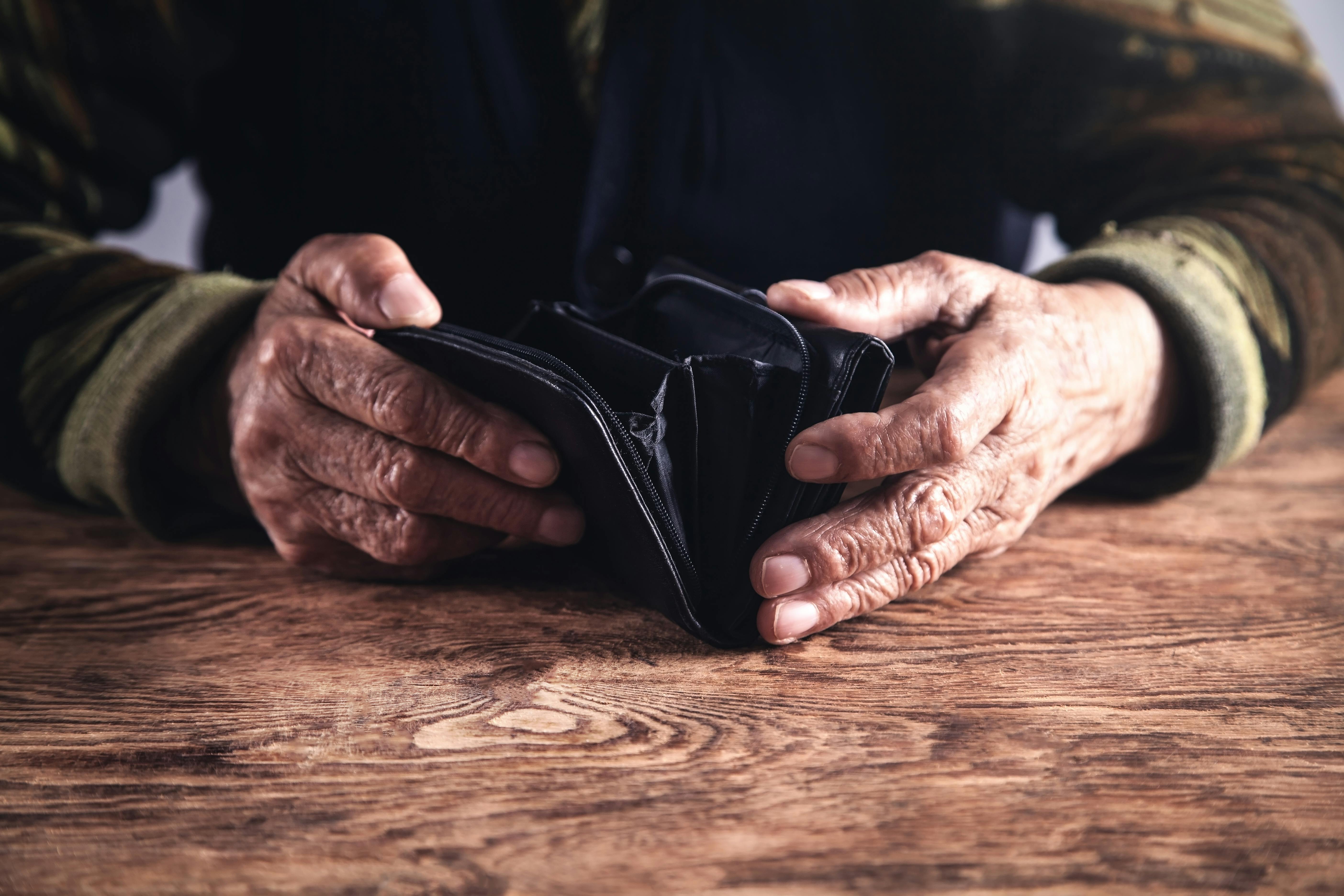 Elderly woman with empty wallet. 
