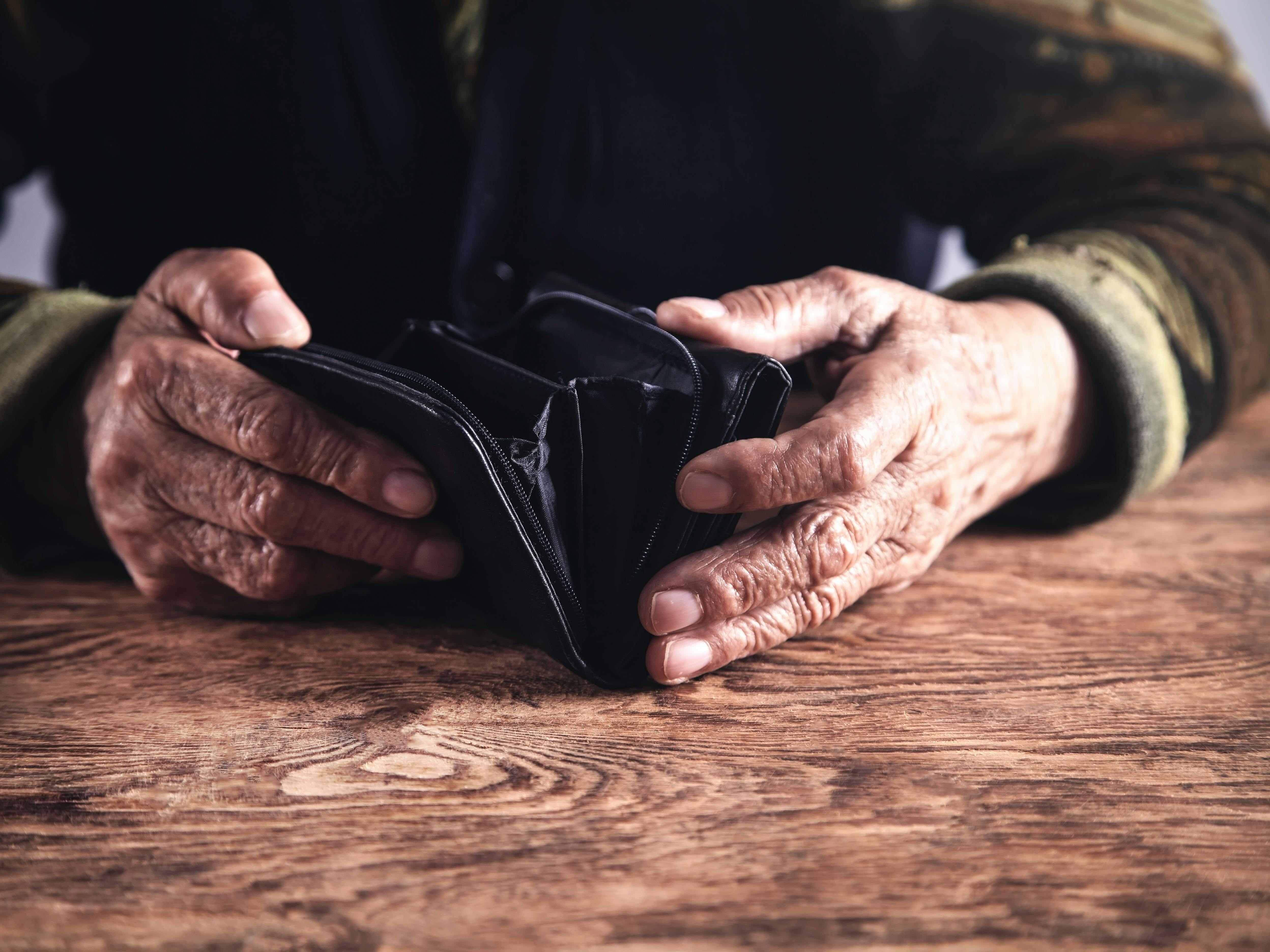 Elderly woman with empty wallet. 
