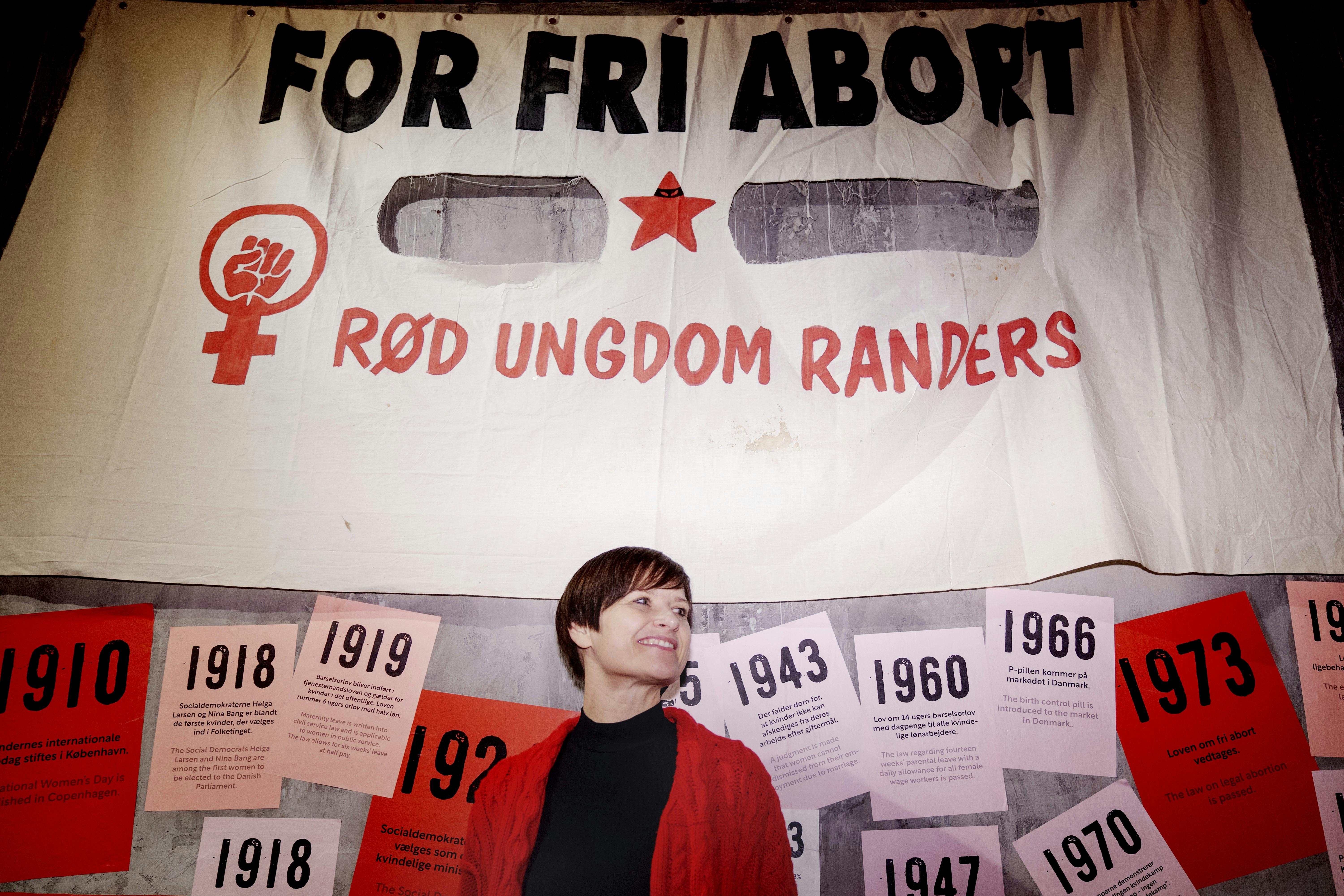 Linda Nørgaard foran et "fri abort"-banner i udstillingen