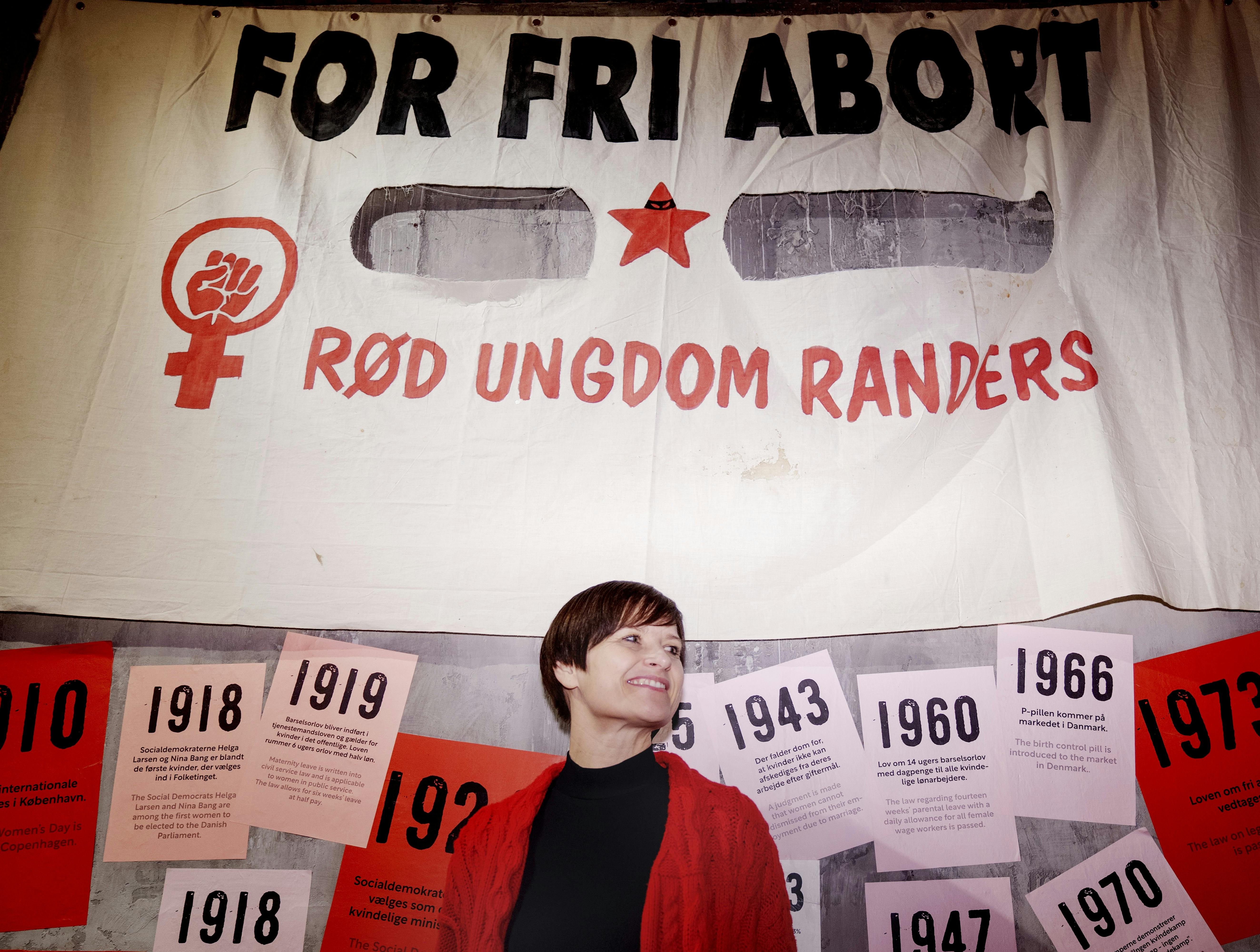 Linda Nørgaard foran et "fri abort"-banner i udstillingen