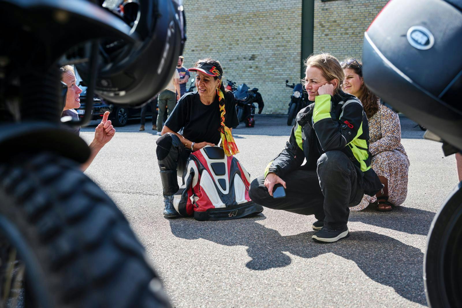 Fatma Andersen lytter opmærksomt, mens motorcykelmekaniker Pia Steen forklarer om dækpleje. 
