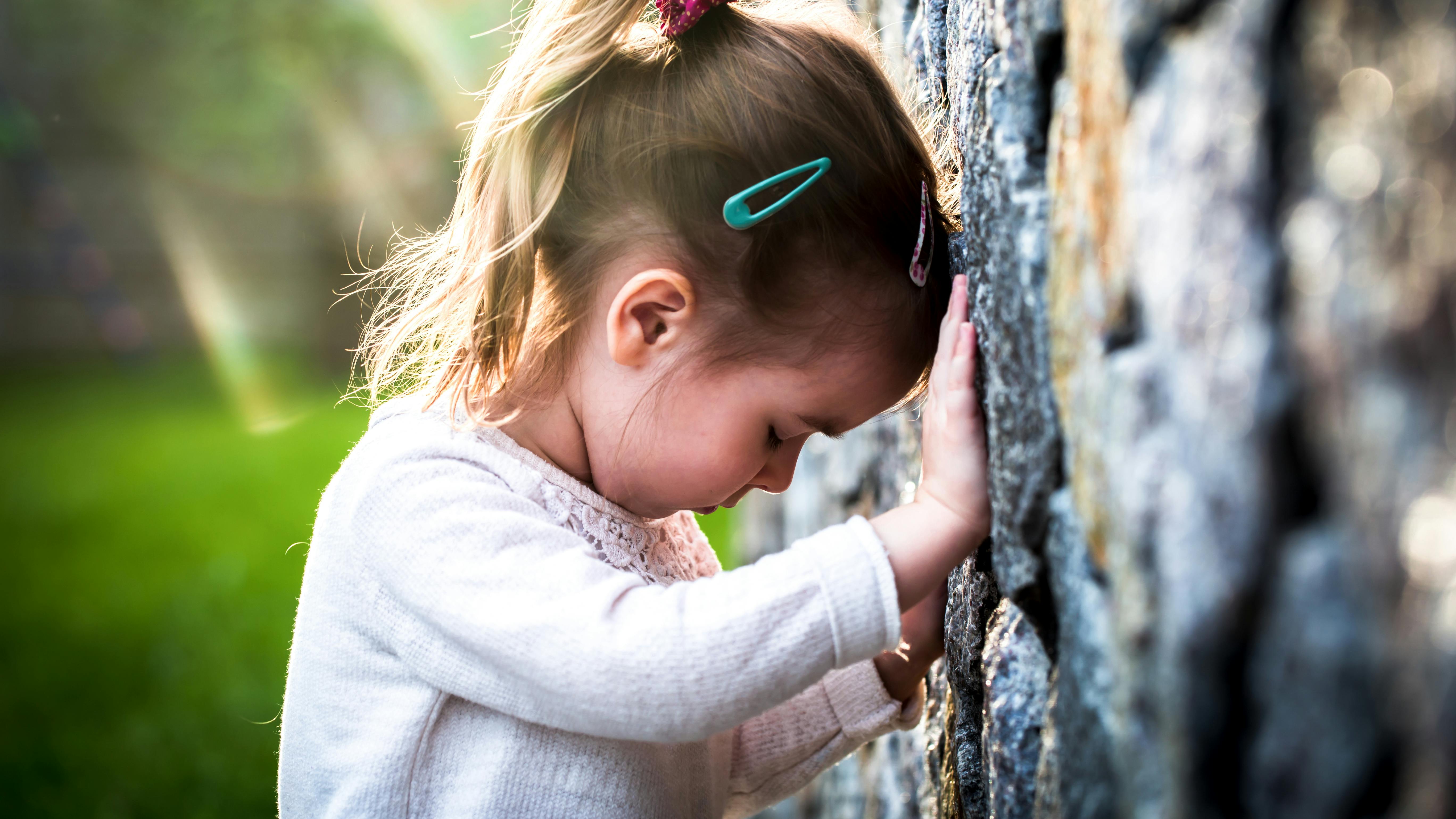 emotion girl sitting near wall in the day time, beautiful background