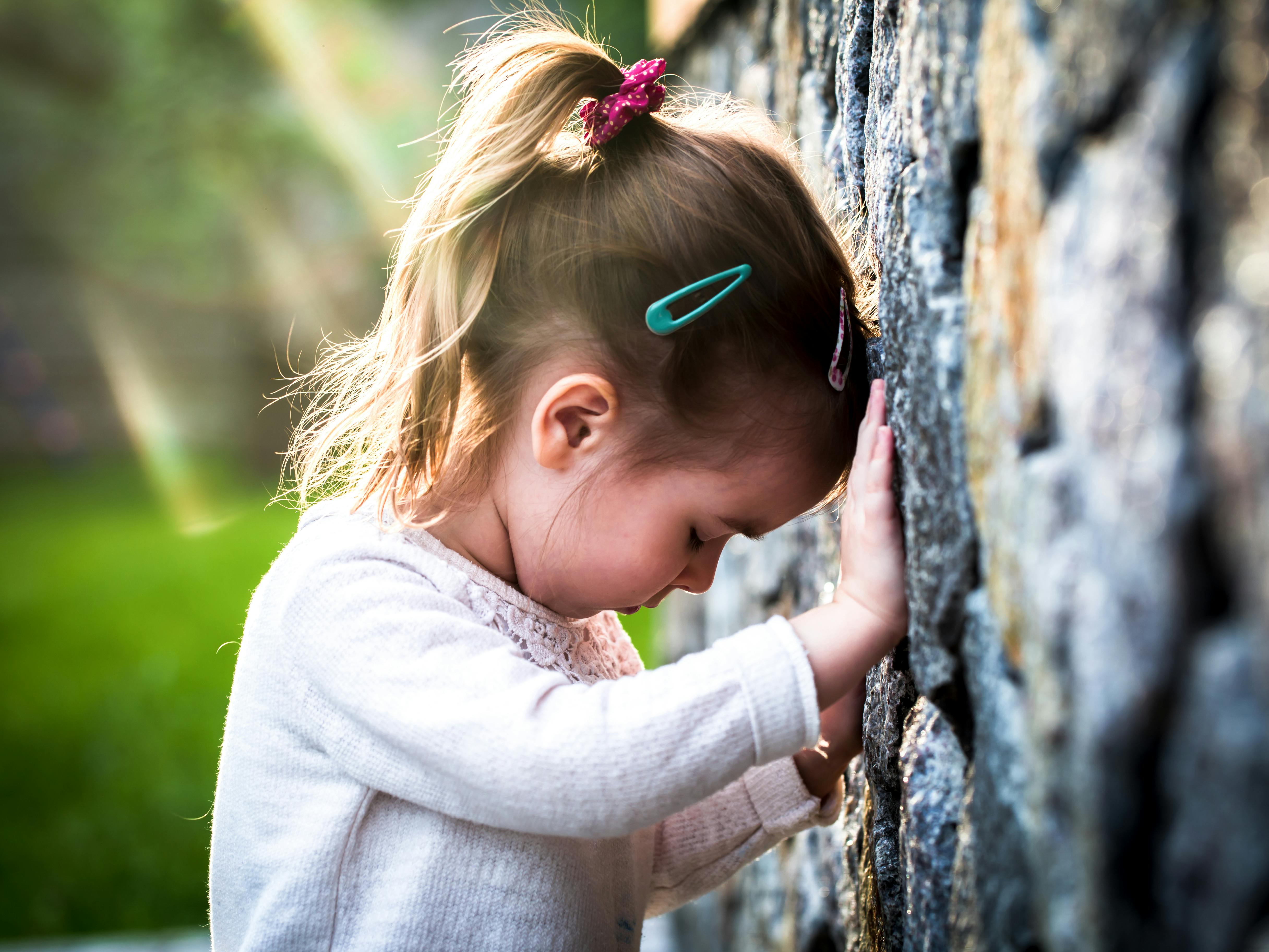 emotion girl sitting near wall in the day time, beautiful background