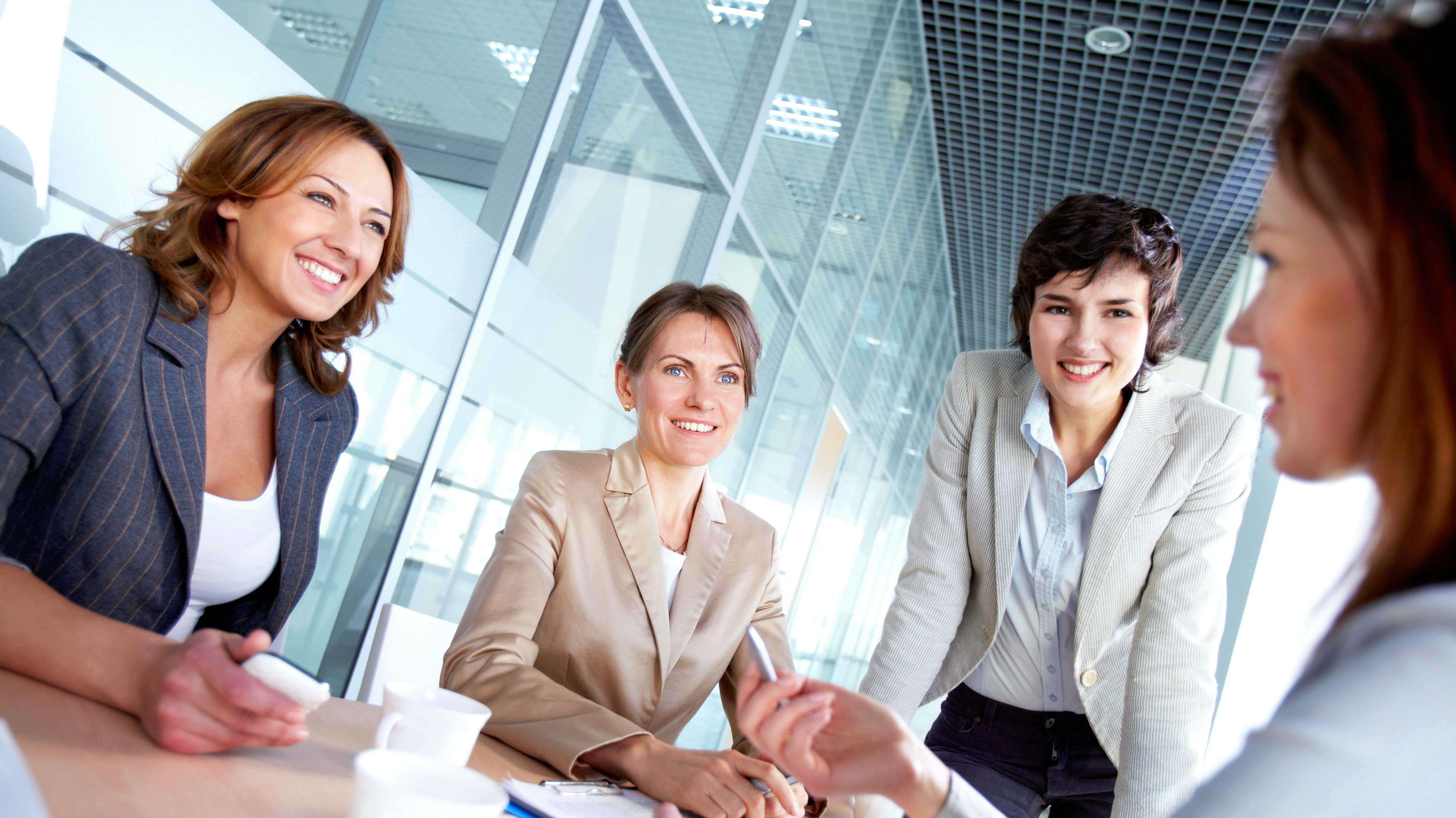 Image of successful females listening to colleague at meeting