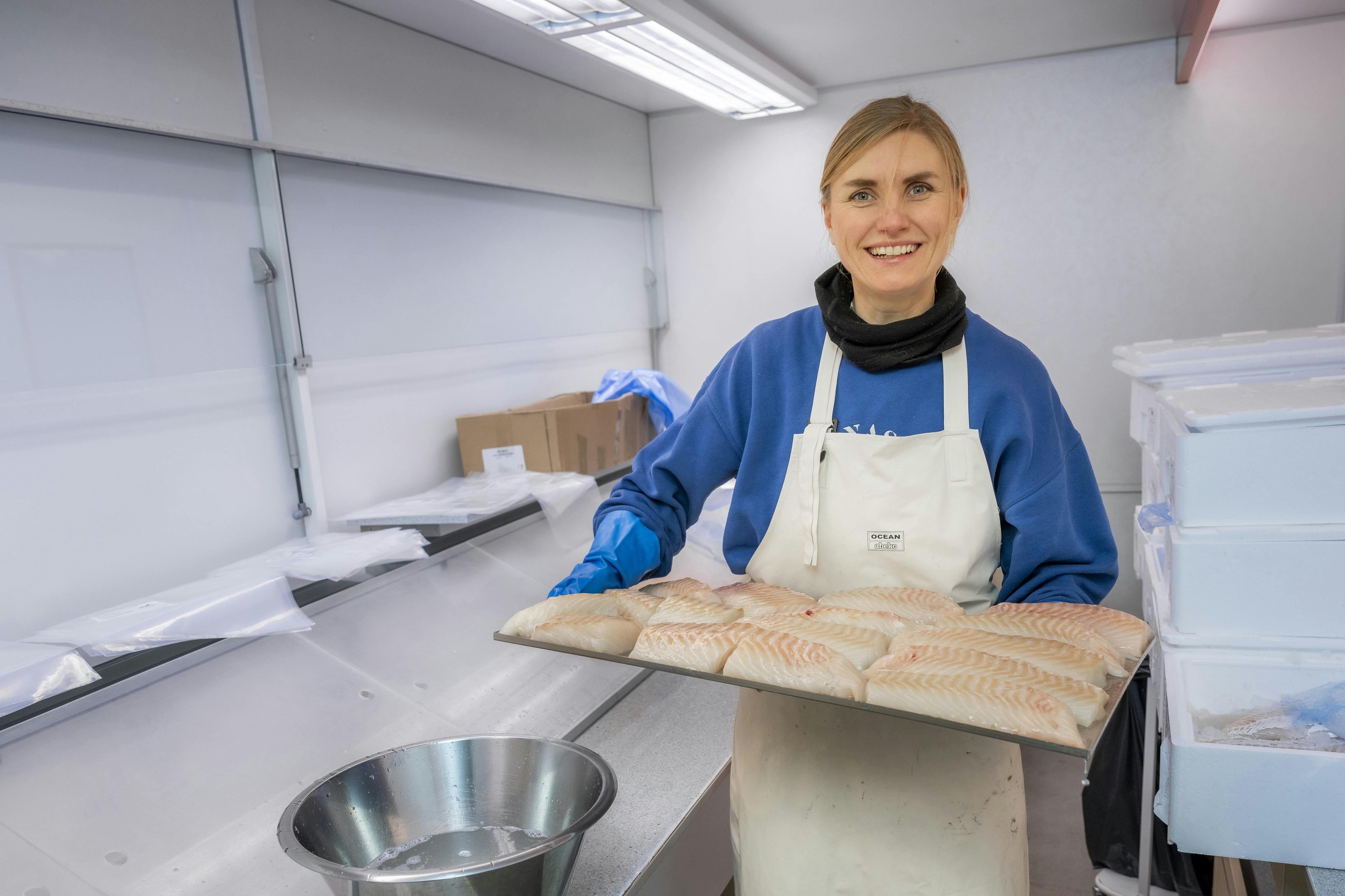 Anna står med frisk fisk i hænderne