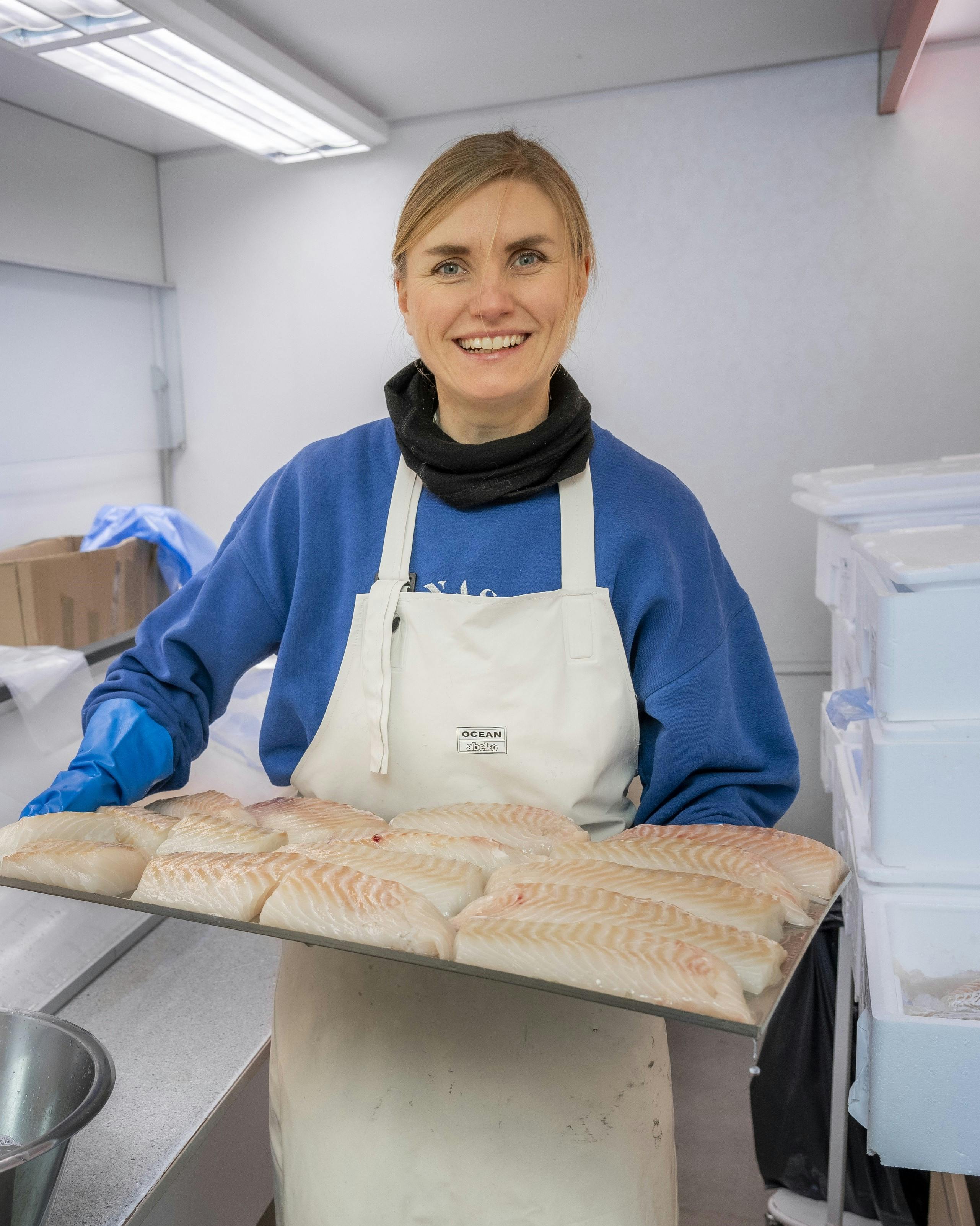 Anna står med frisk fisk i hænderne