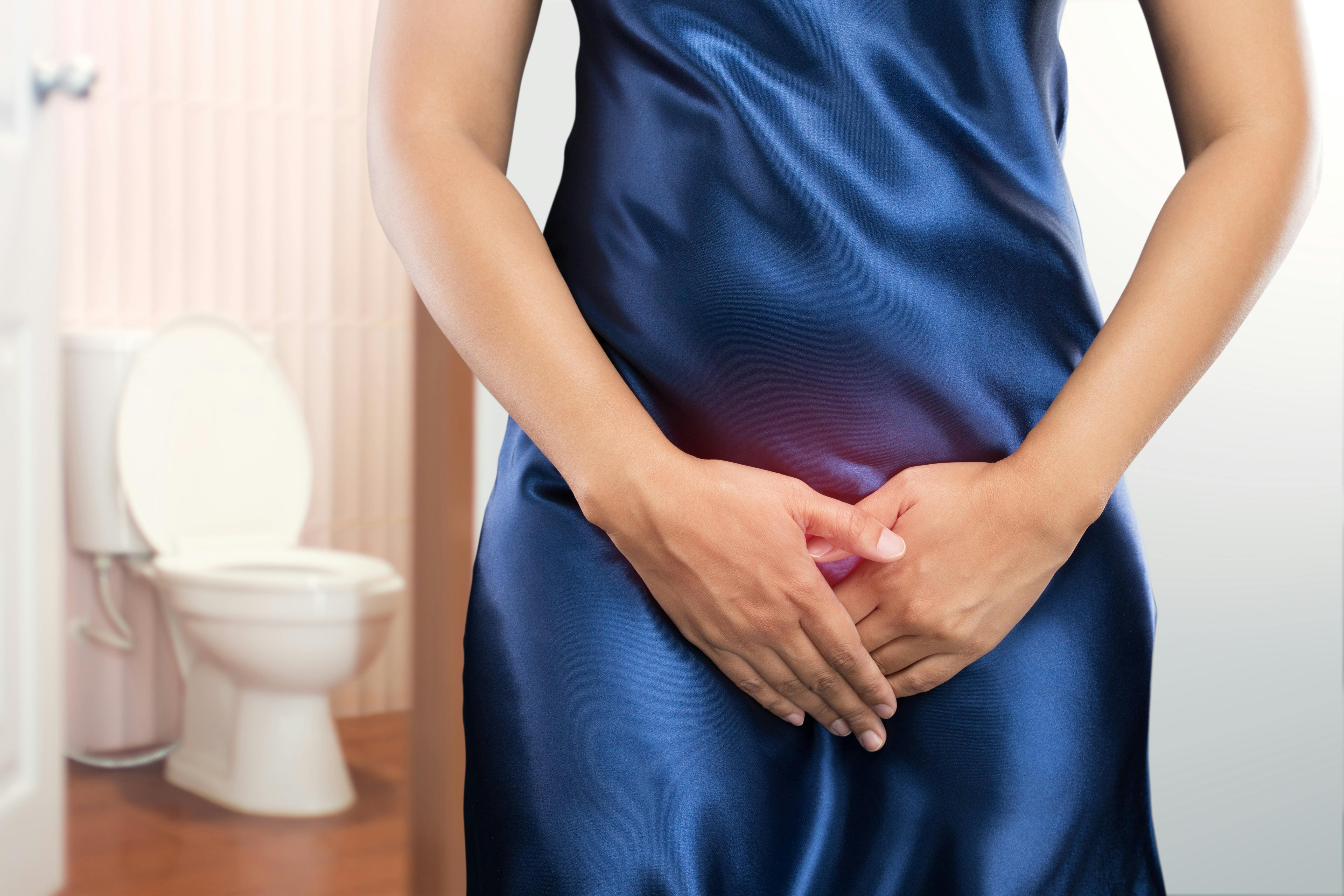 Woman with prostate problem in front of toilet bowl. Lady with hands holding her crotch, People wants to pee - urinary incontinence concept