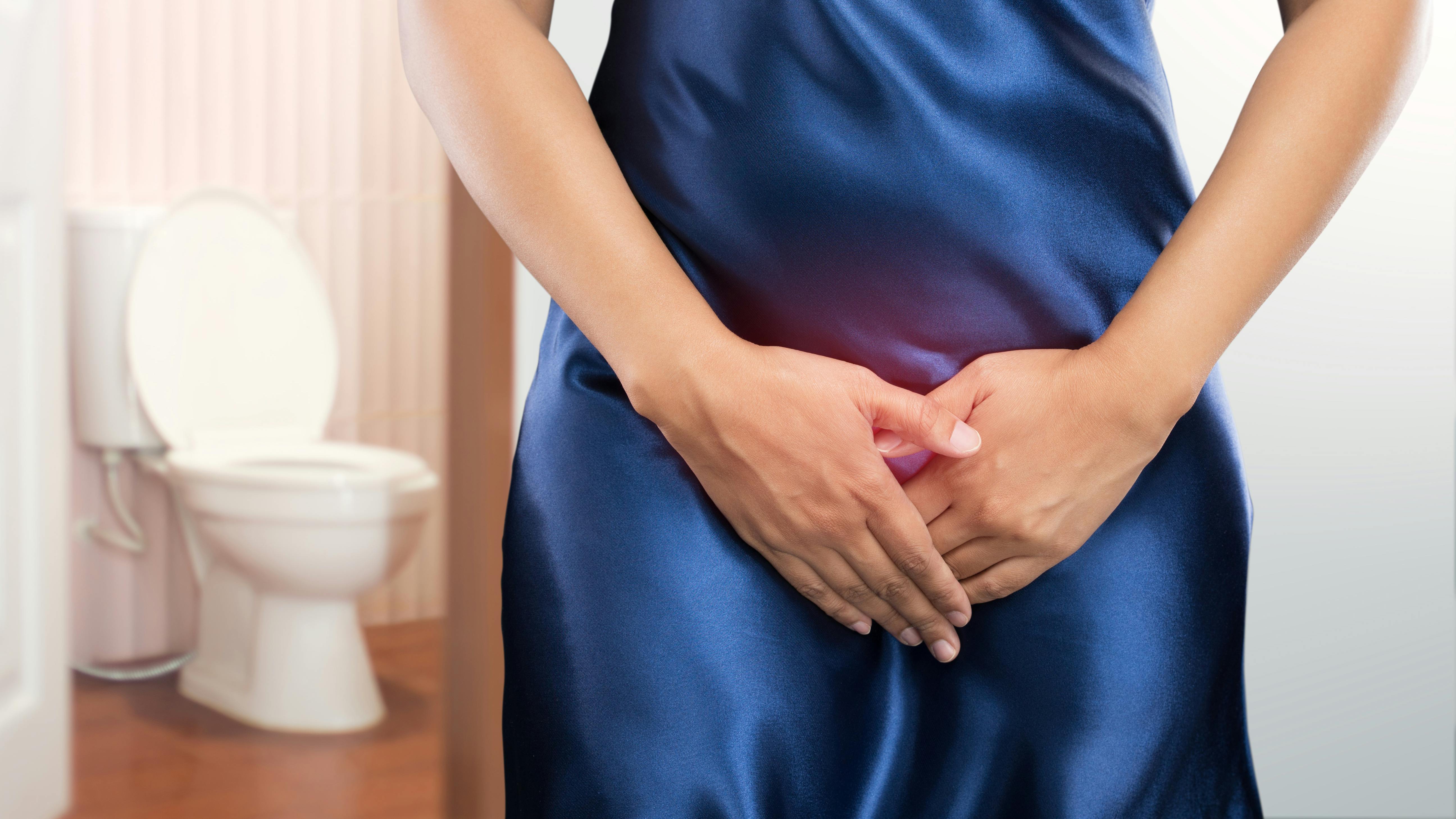 Woman with prostate problem in front of toilet bowl. Lady with hands holding her crotch, People wants to pee - urinary incontinence concept