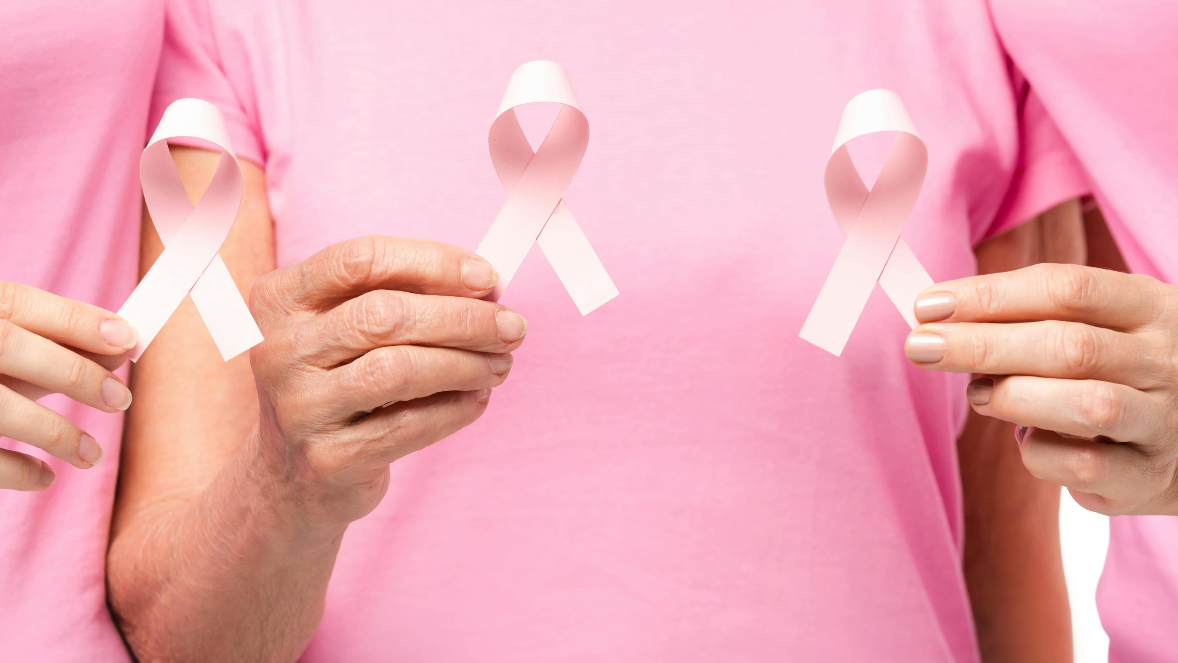 Tre kvinder holder knæk cancer symbolet