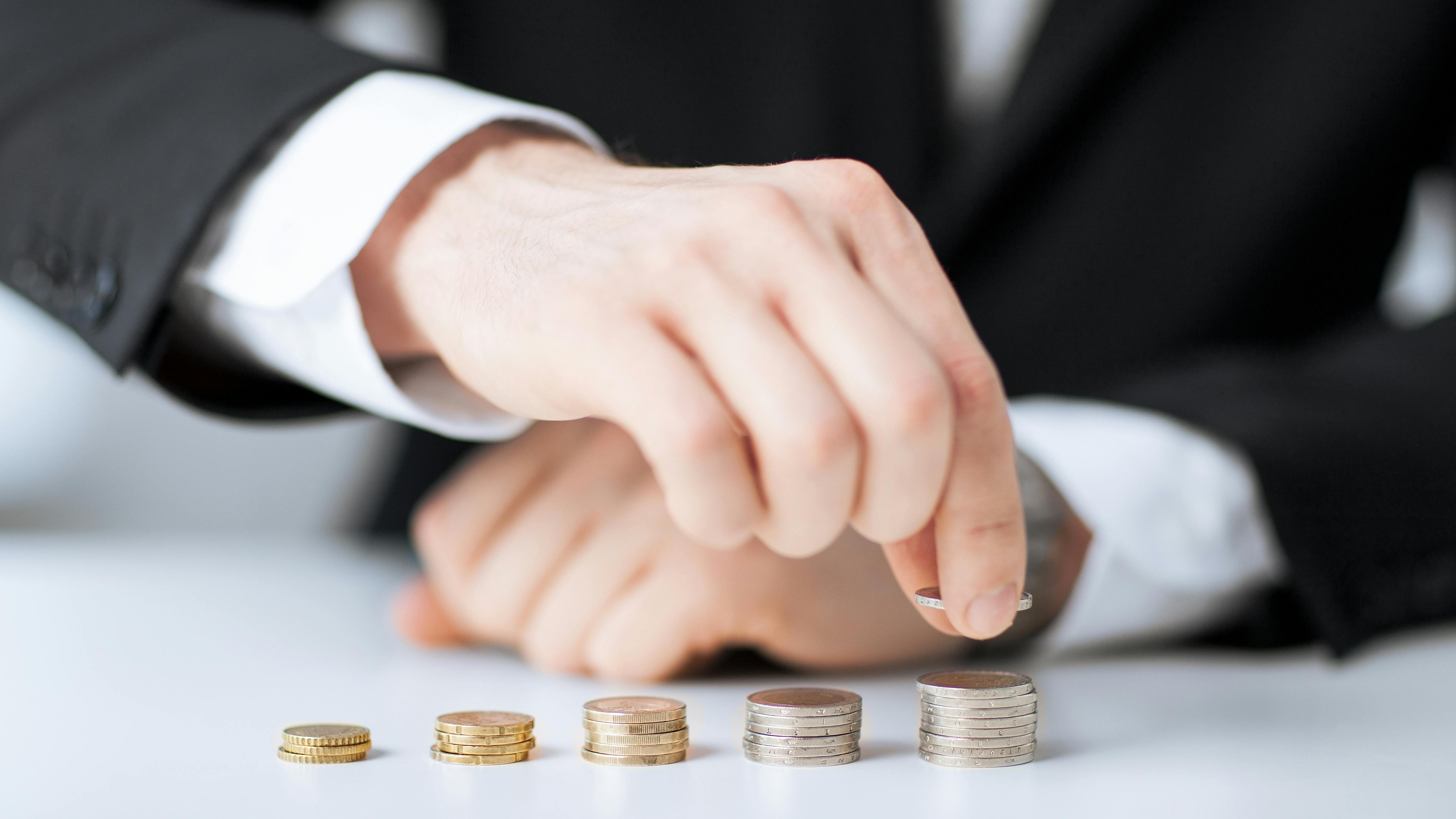 picture of man putting stack of coins into one row