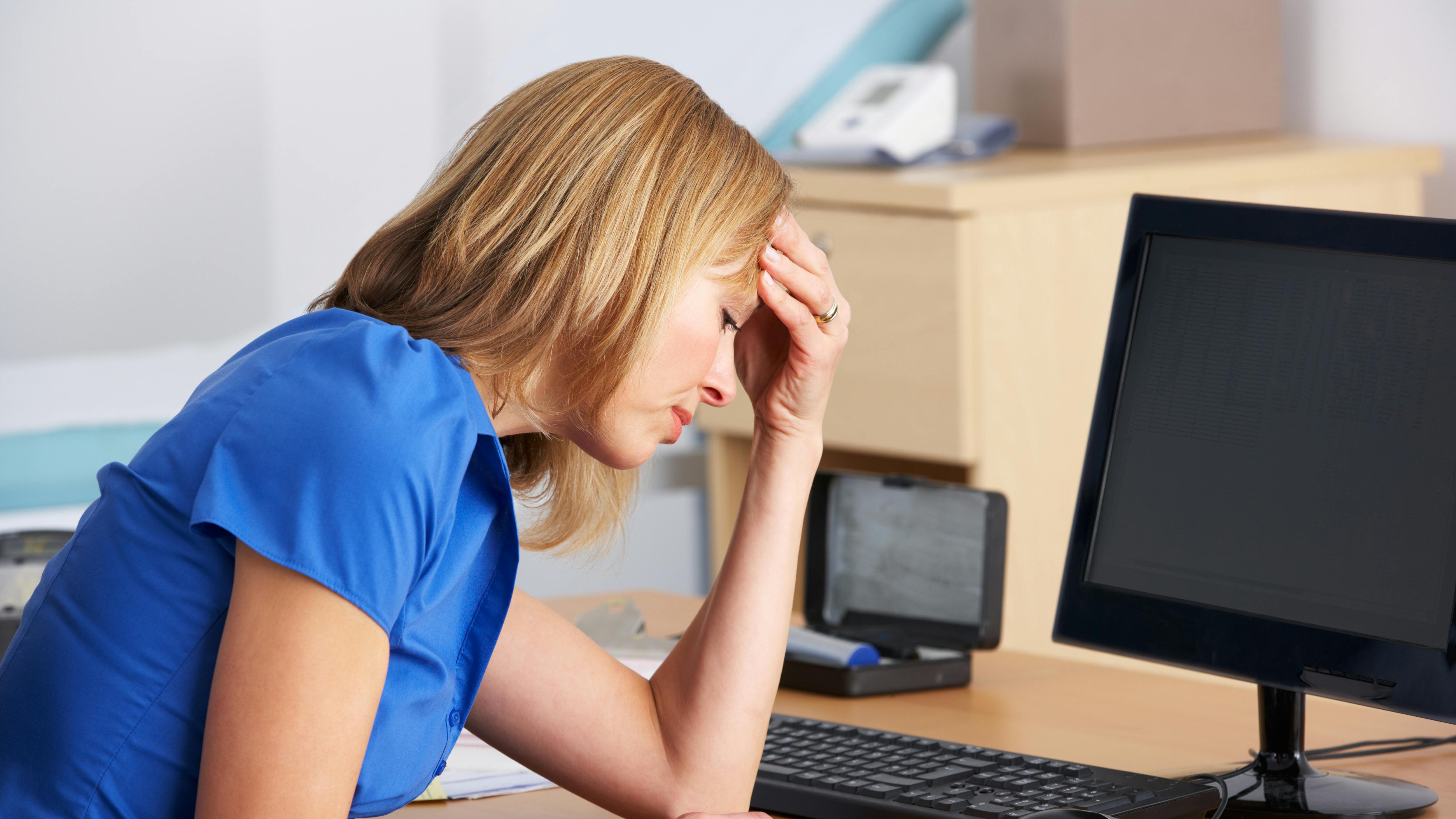 Stresset kvinde sidder ved et bord