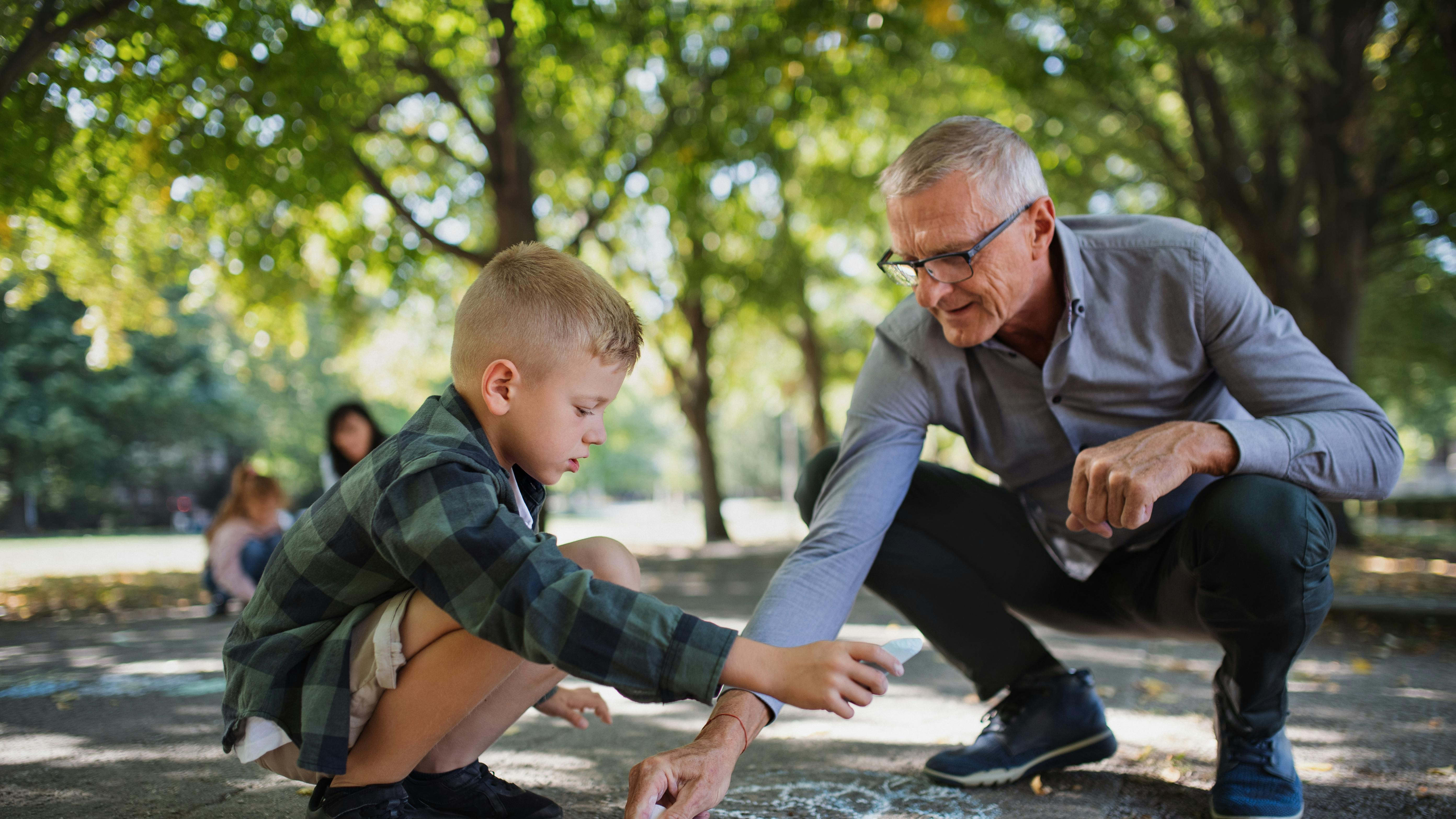 barnebarn og bedstefar leger med kridt