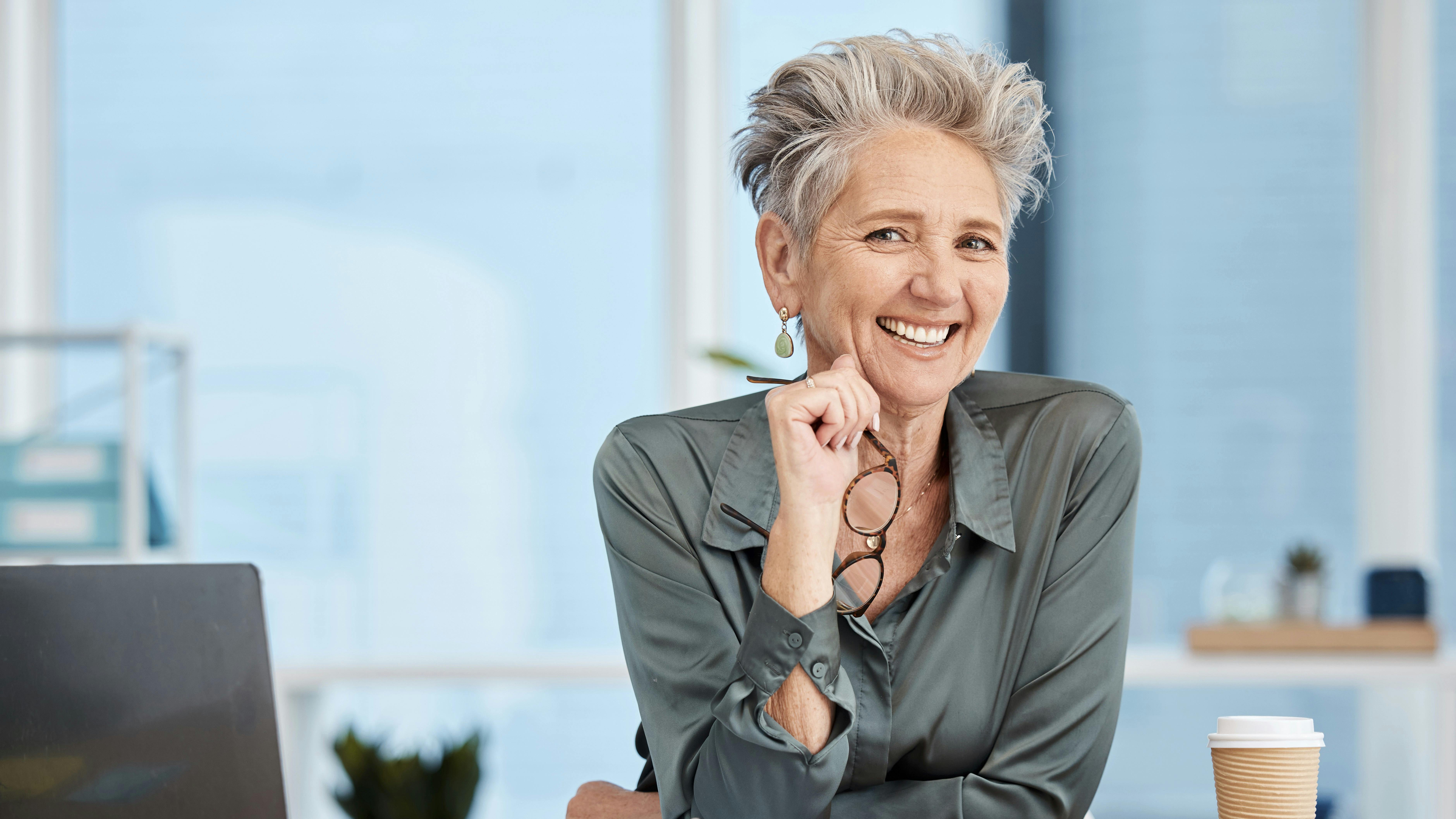 Kvinde, der sidder ved sit arbejds skrivebord.