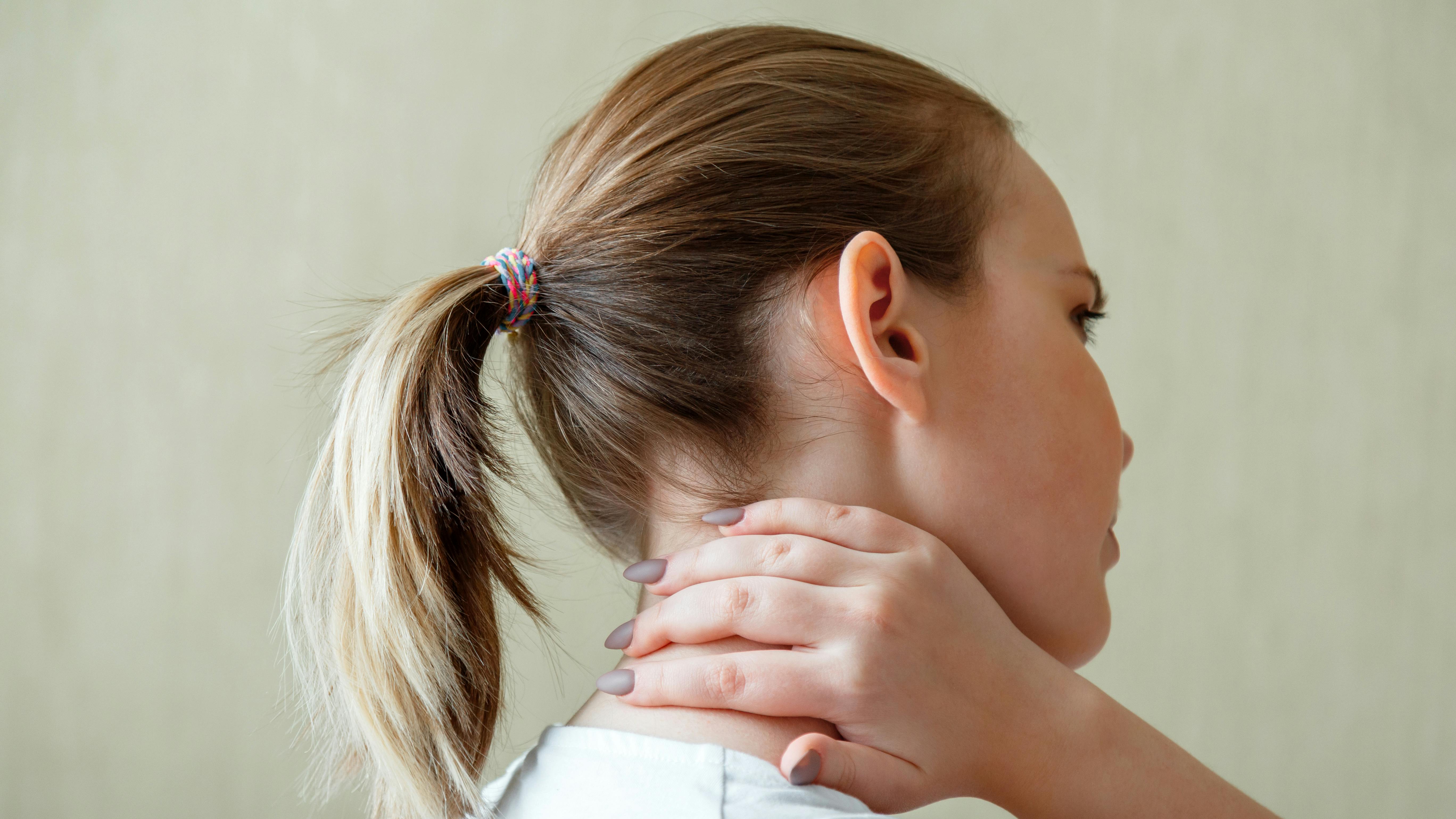 kvinde med smerter i skulder og ryg