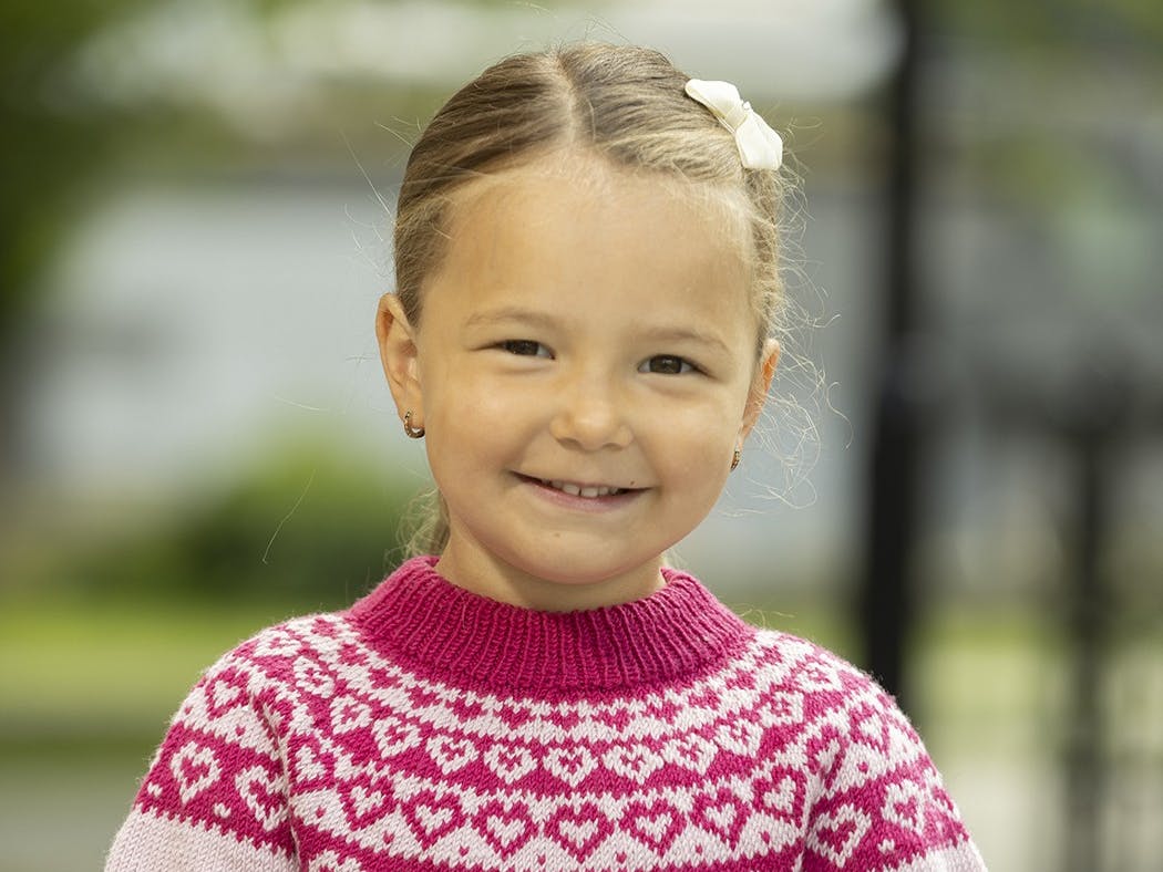 Lille pige med sweater med små hjerter på.