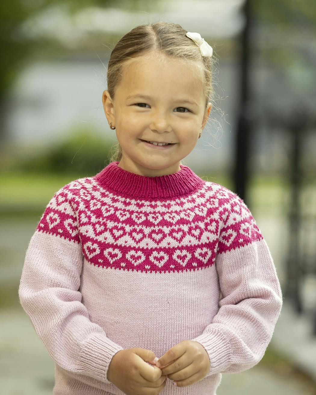 Lille pige med sweater med små hjerter på.
