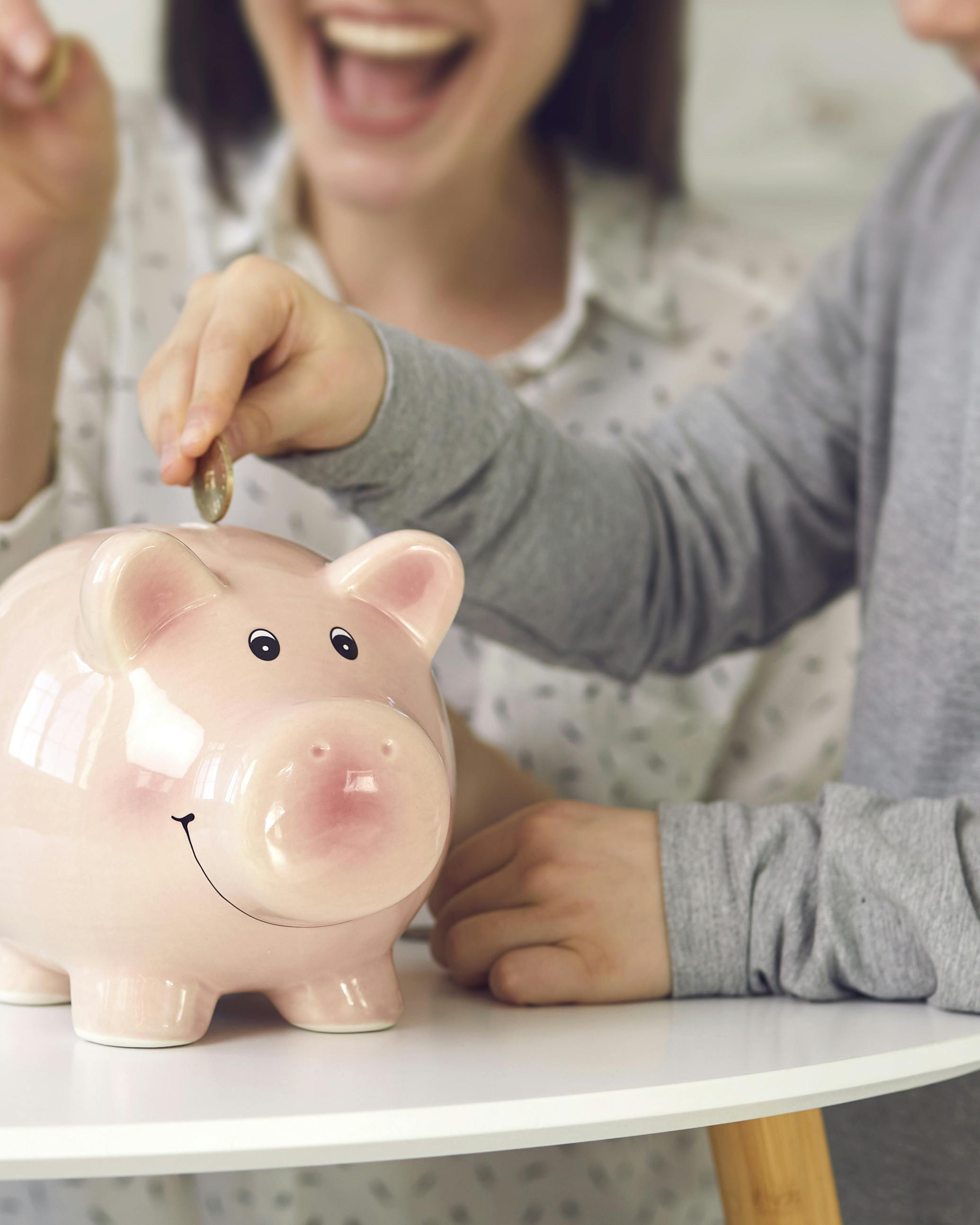 En mor putter penge i en sparegris med sine tre børn