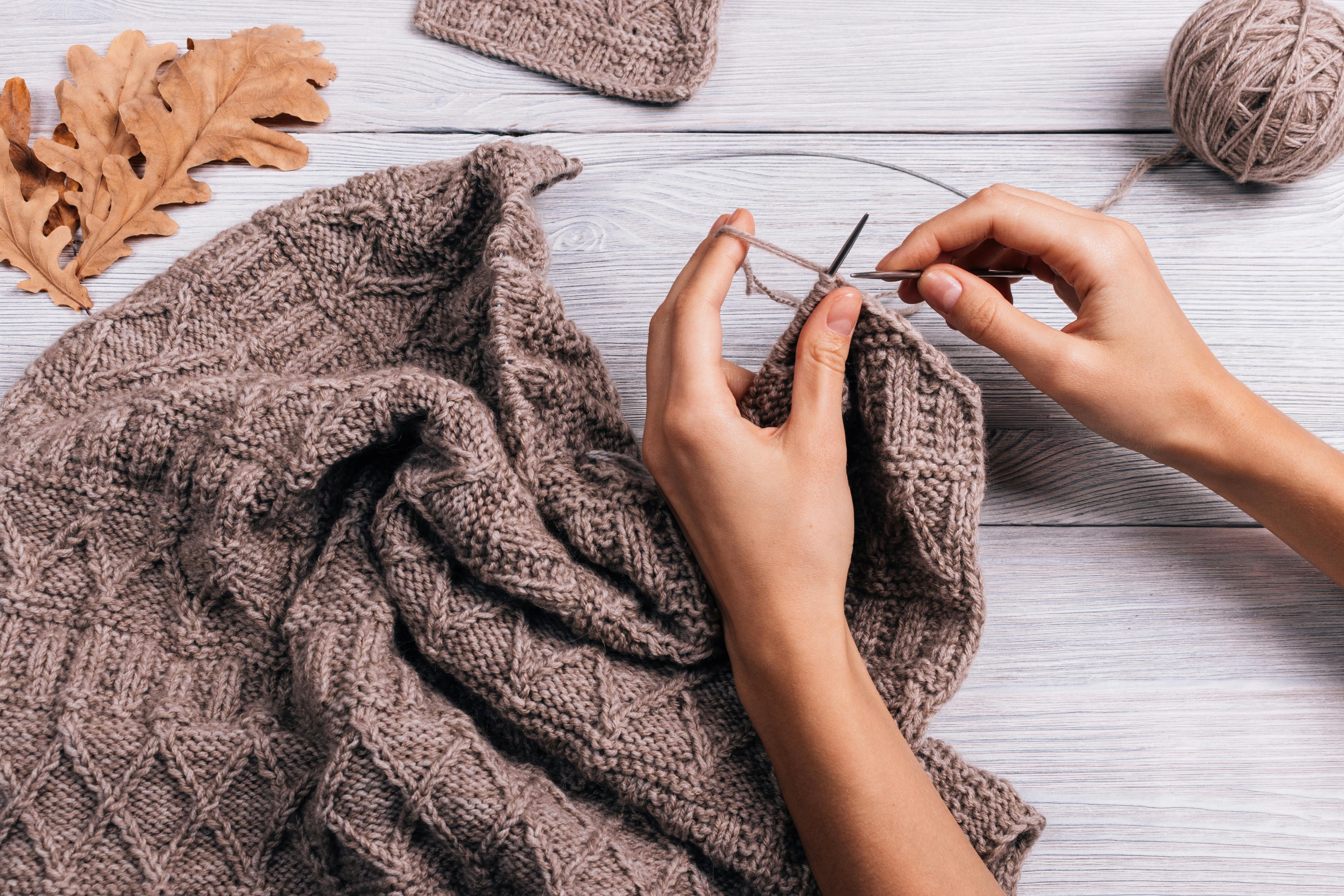 Hænder der strikker en sweater