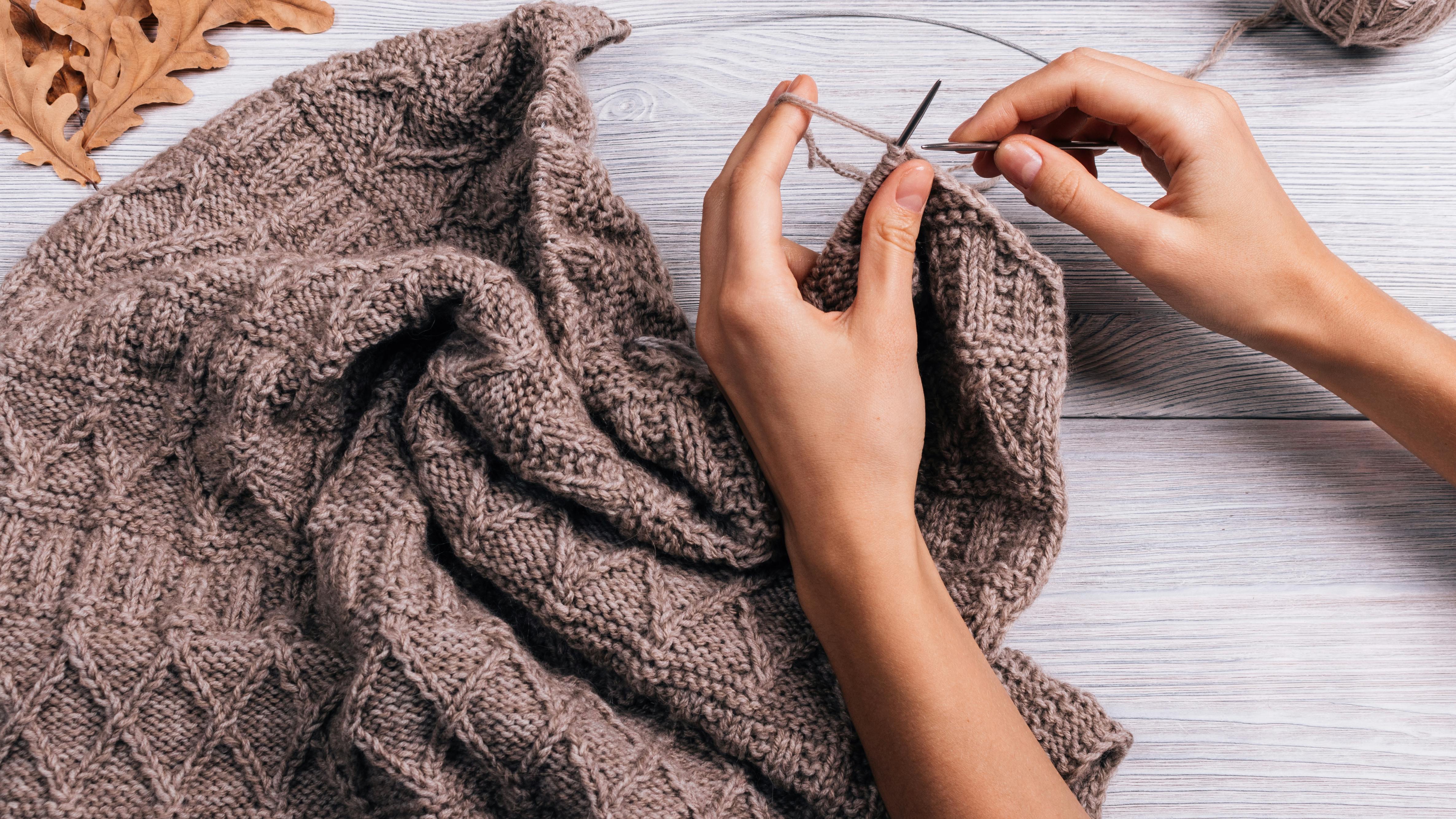 Hænder der strikker en sweater