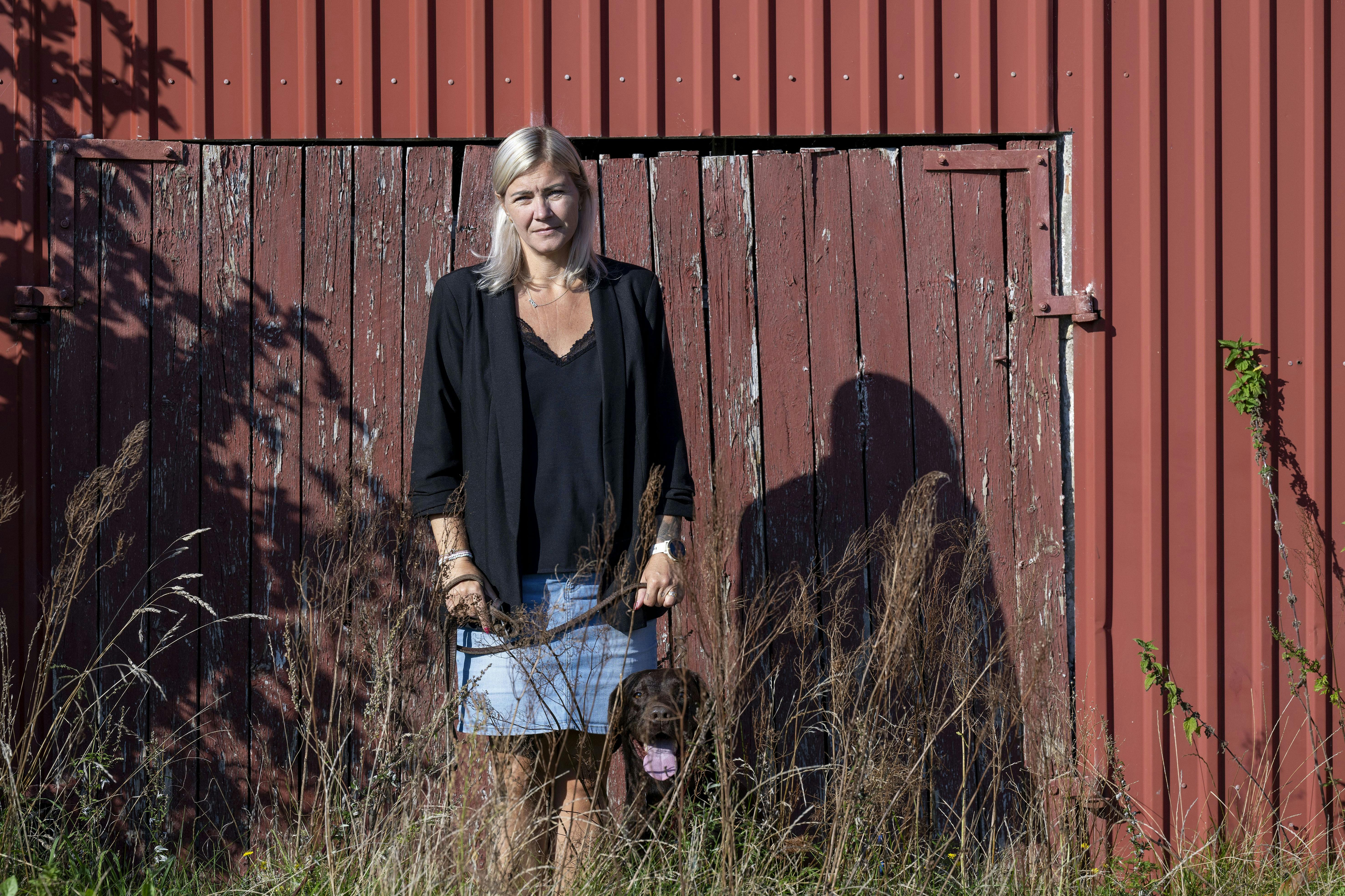 Merete Eliassen foran en stor rød bygning. 