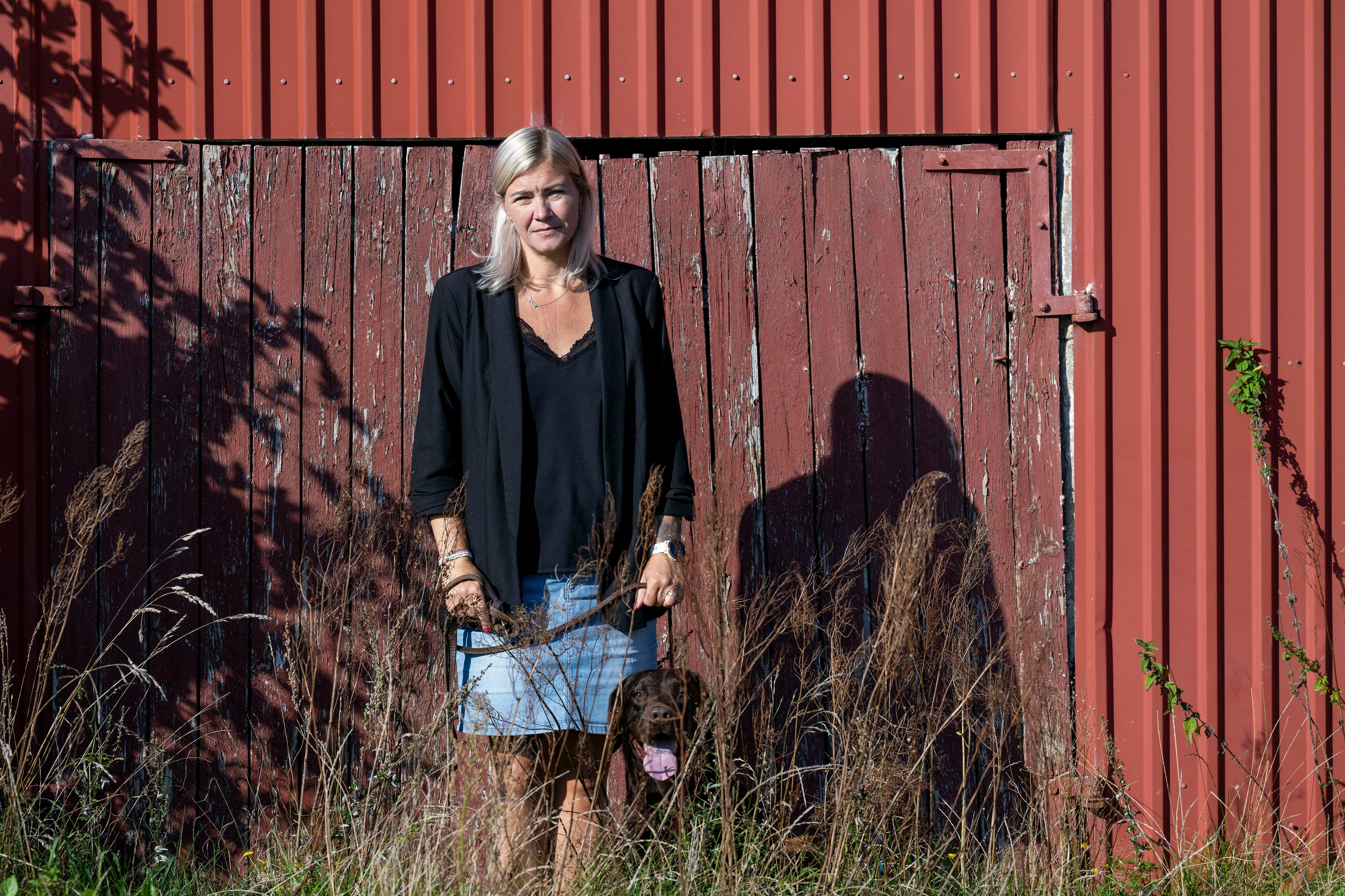 Merete Eliassen foran en stor rød bygning.