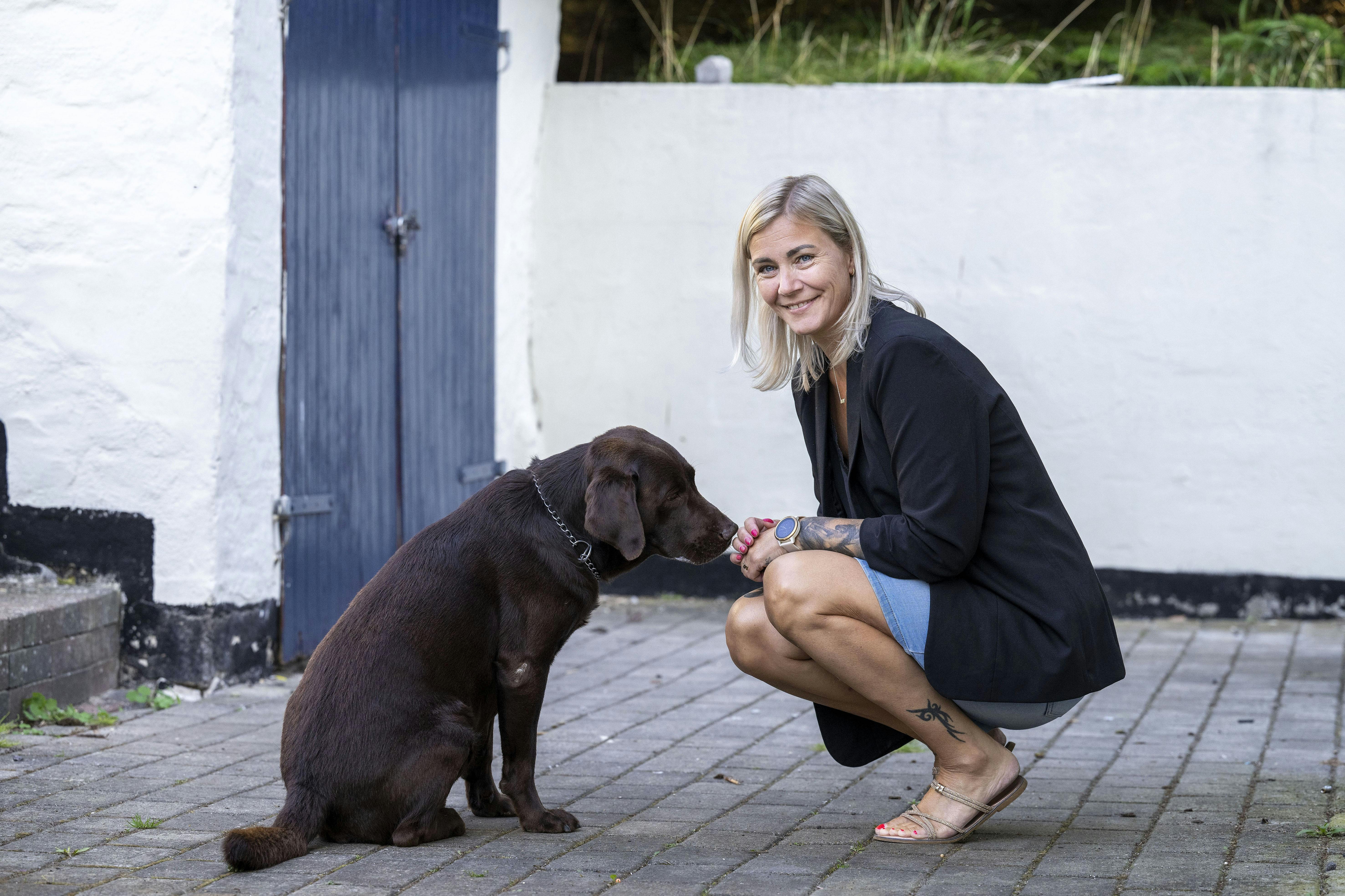 Merete Eliassen, som står sammen med sin hund. 