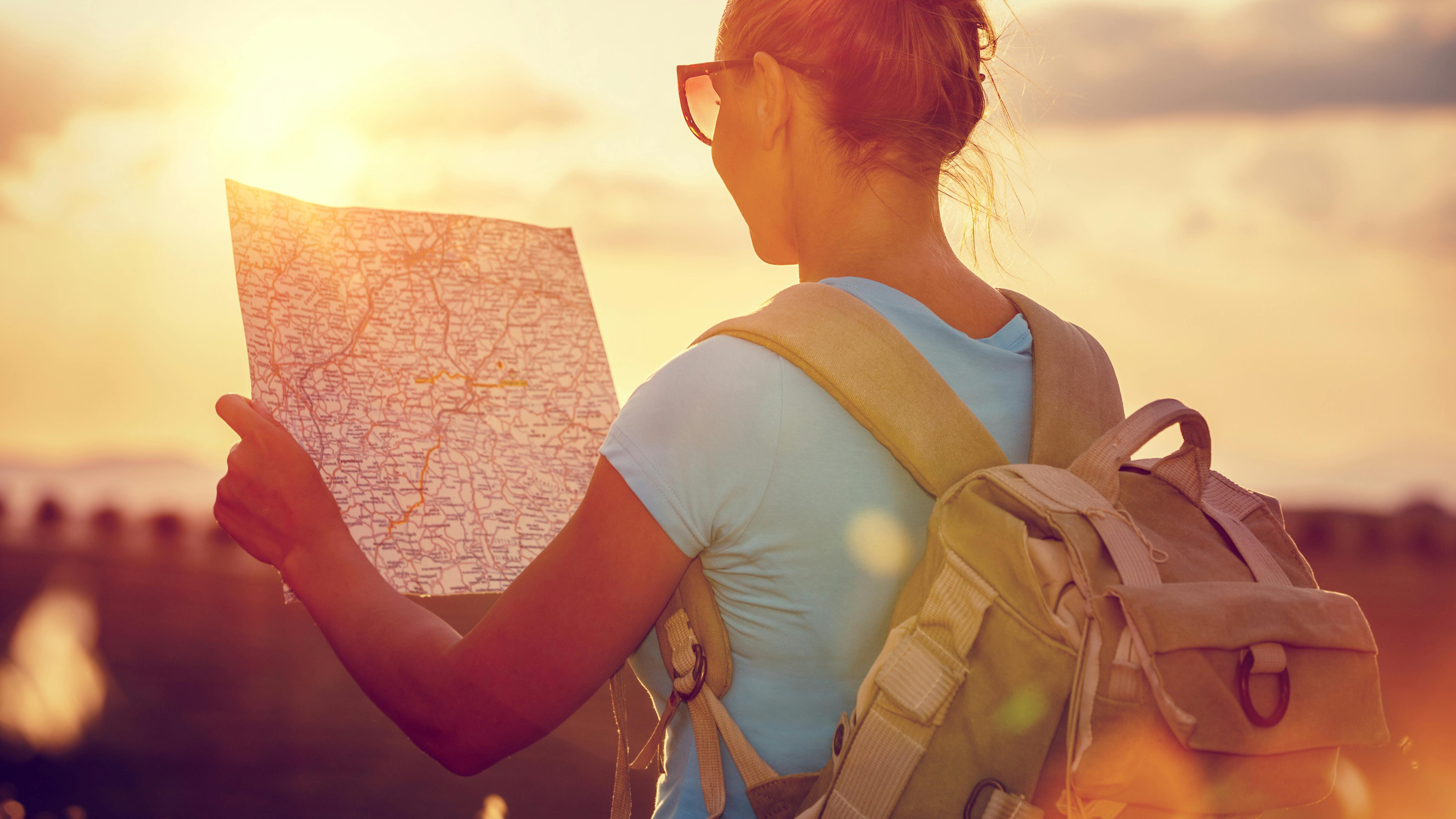 Kvinde der går med et kort over området.