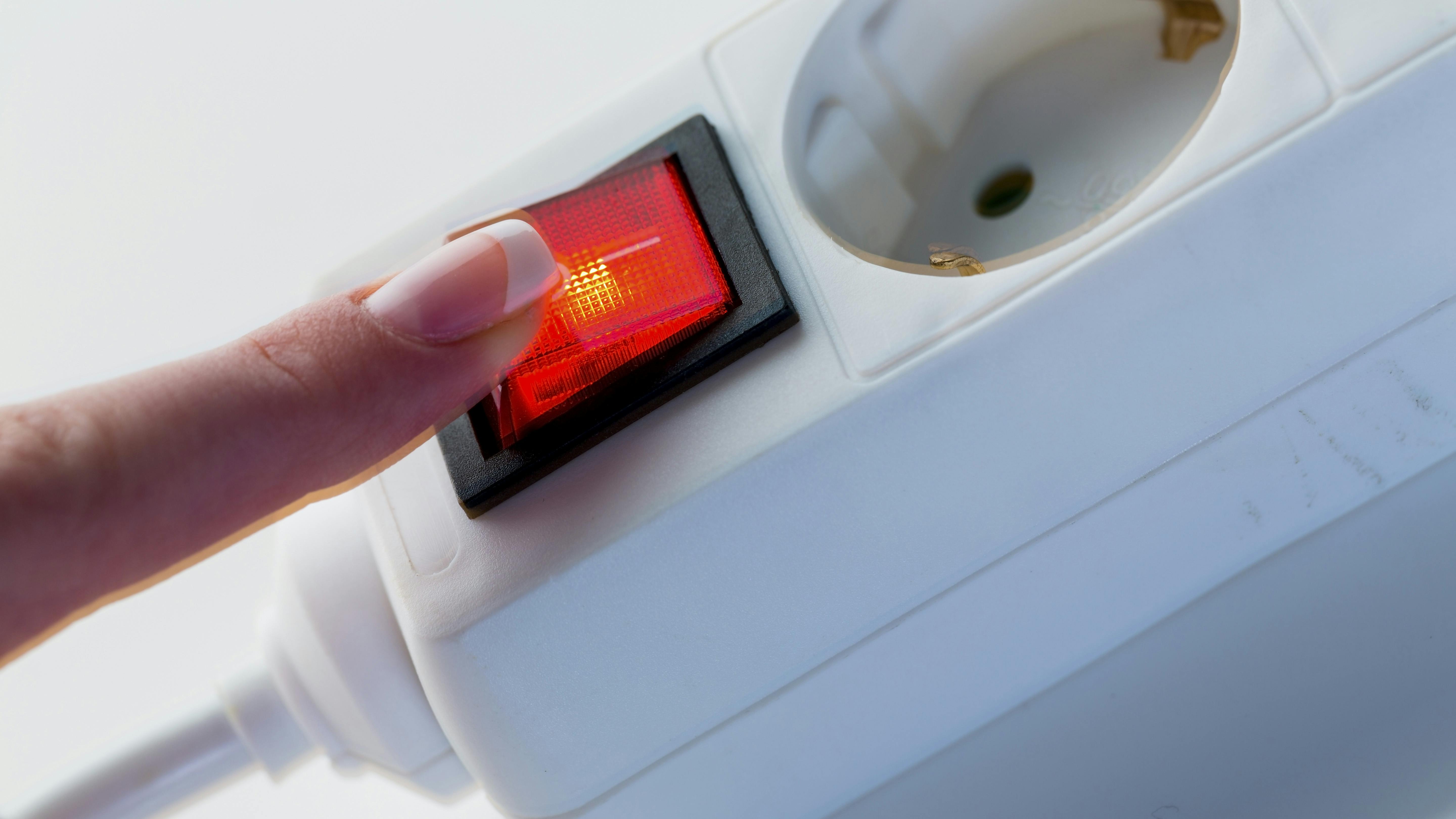 a hand turns off the electricity. symbol photo for problems in the energy