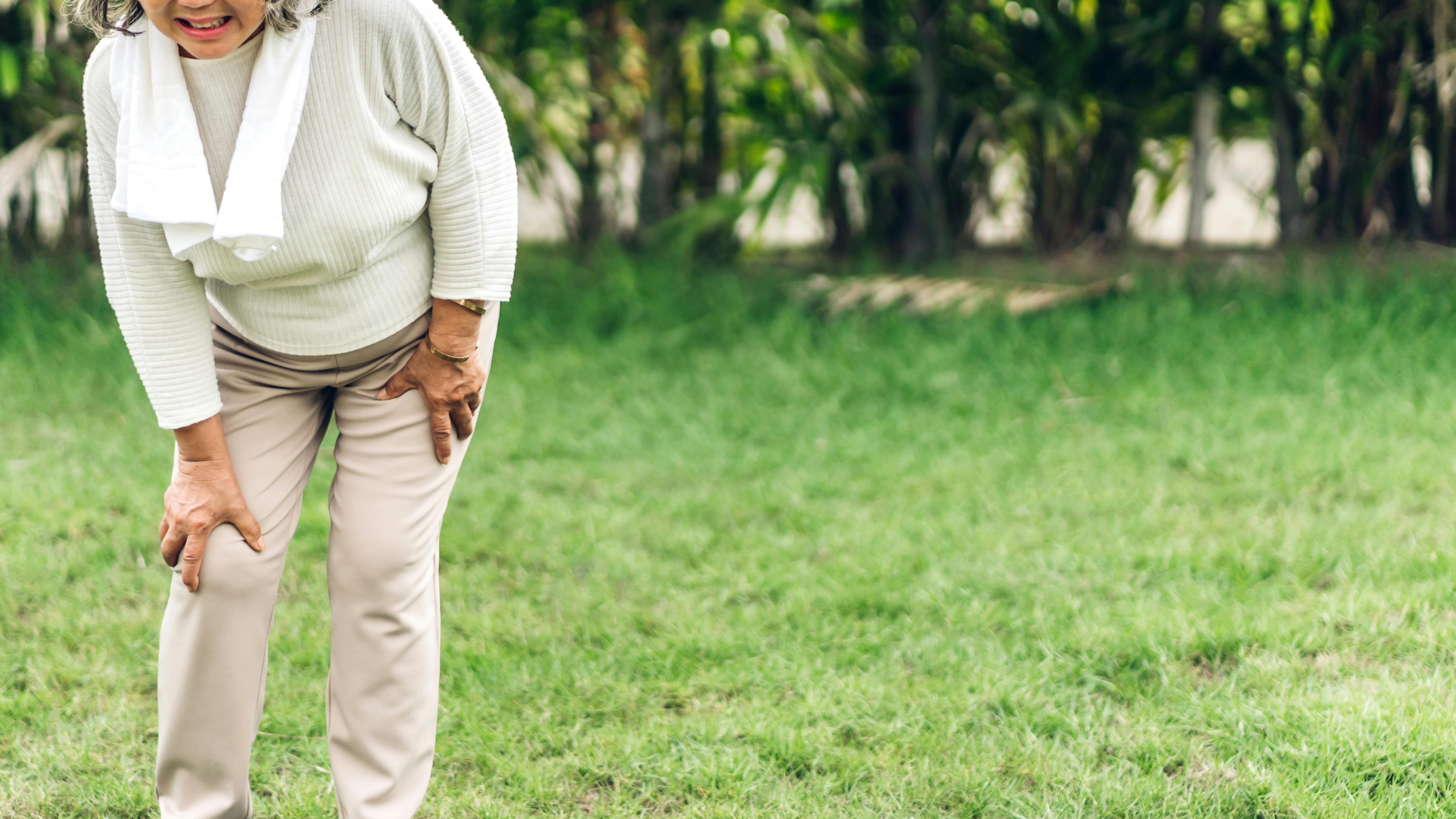 ældre kvinde bøjer sig forover i smerte fra underlivet