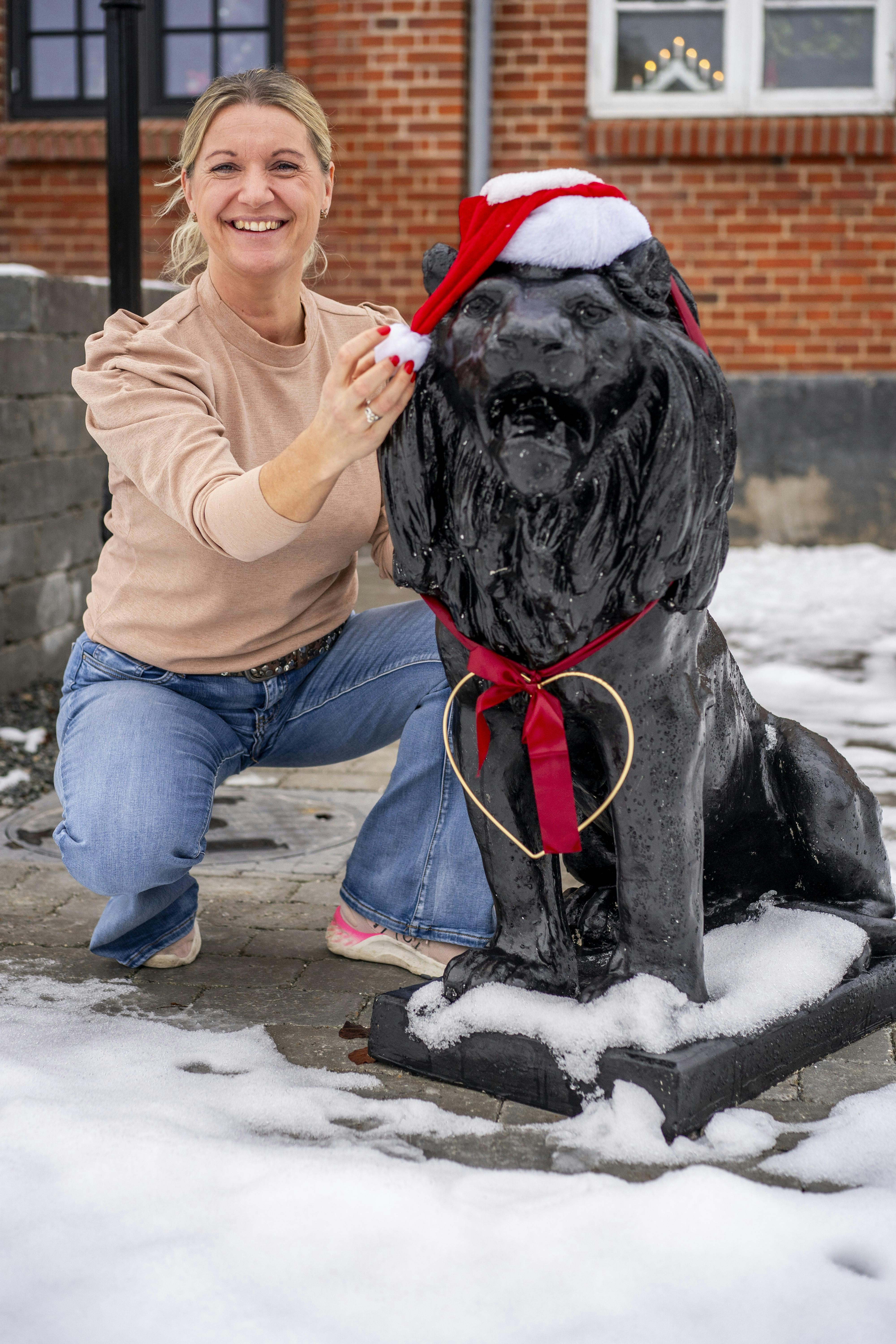 Danse daisy foran sit hus med hendes vagthund statue. 