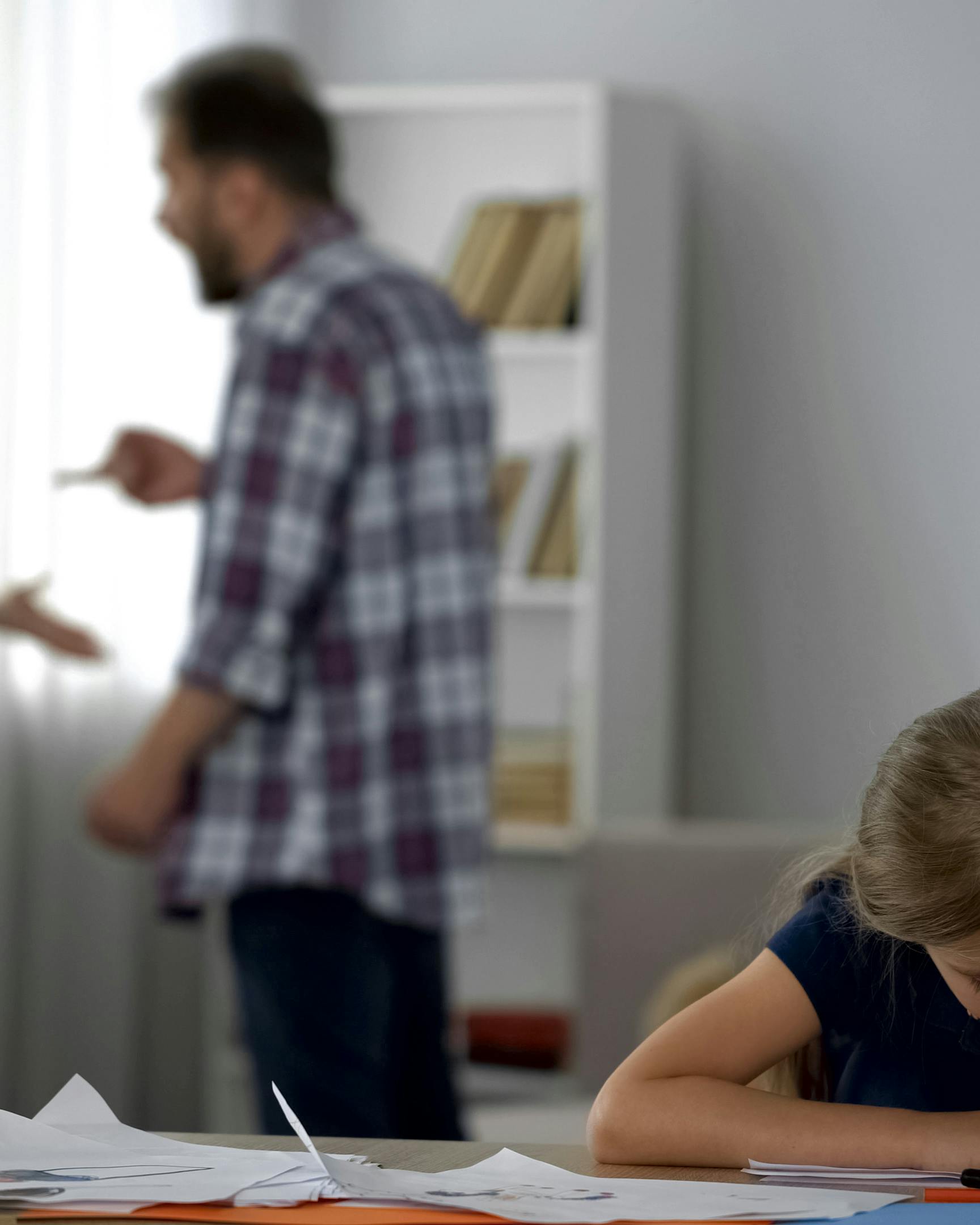 Forældre skændes, mens et barn tegner