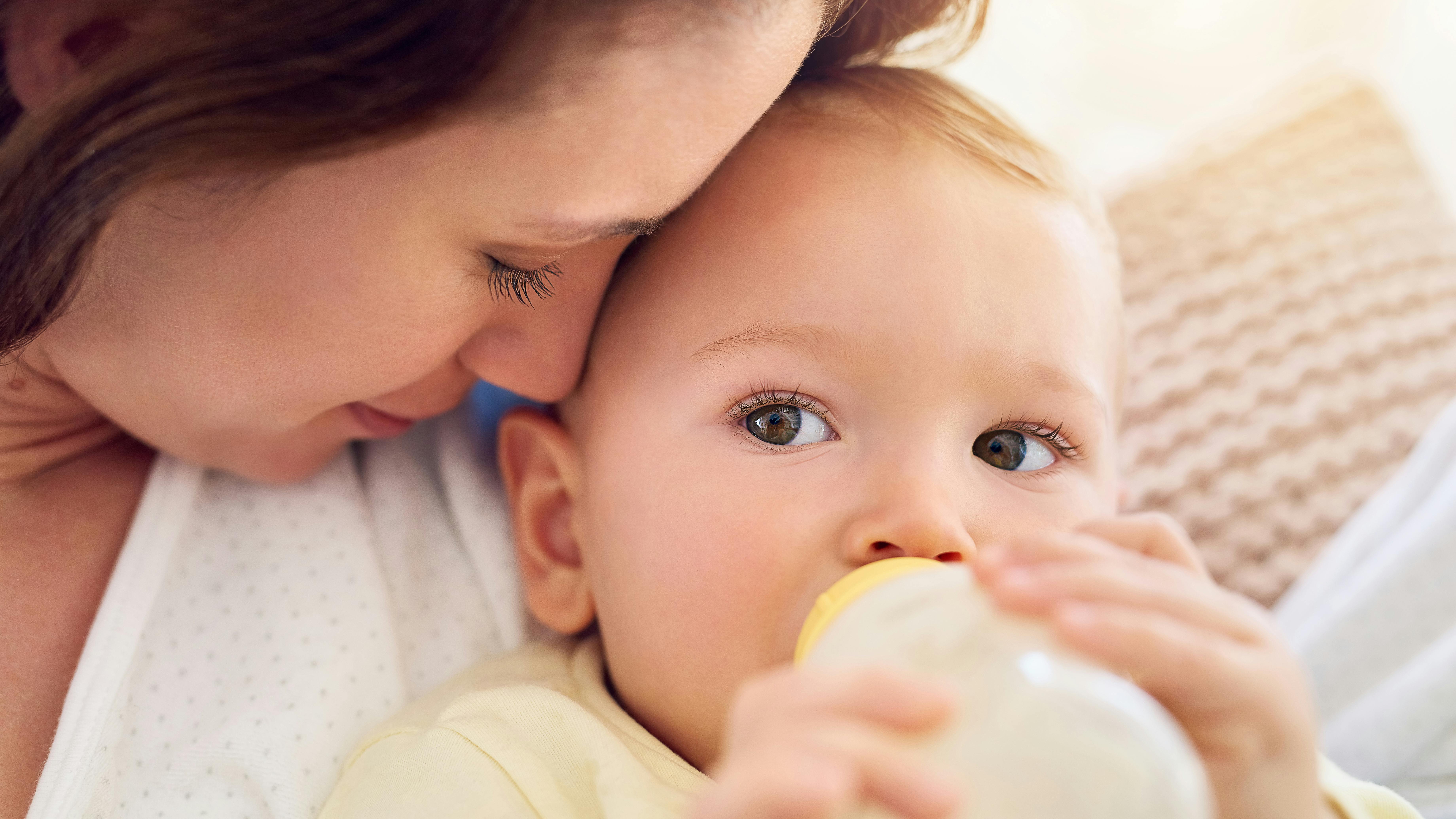 En kvinde der sidder og holder om sit barn.