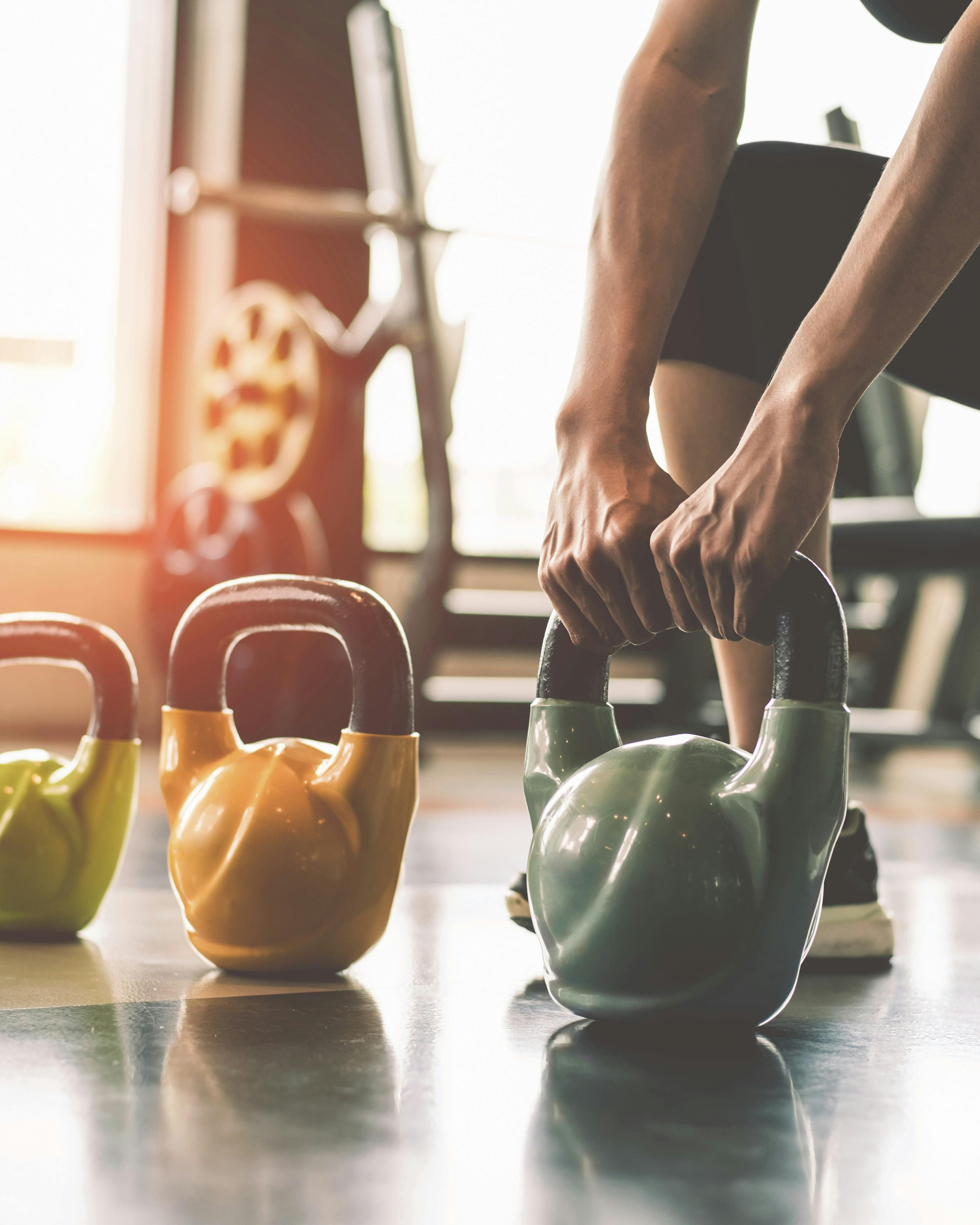 Kvinde, der styrketræner ved at løfte en kettlebell