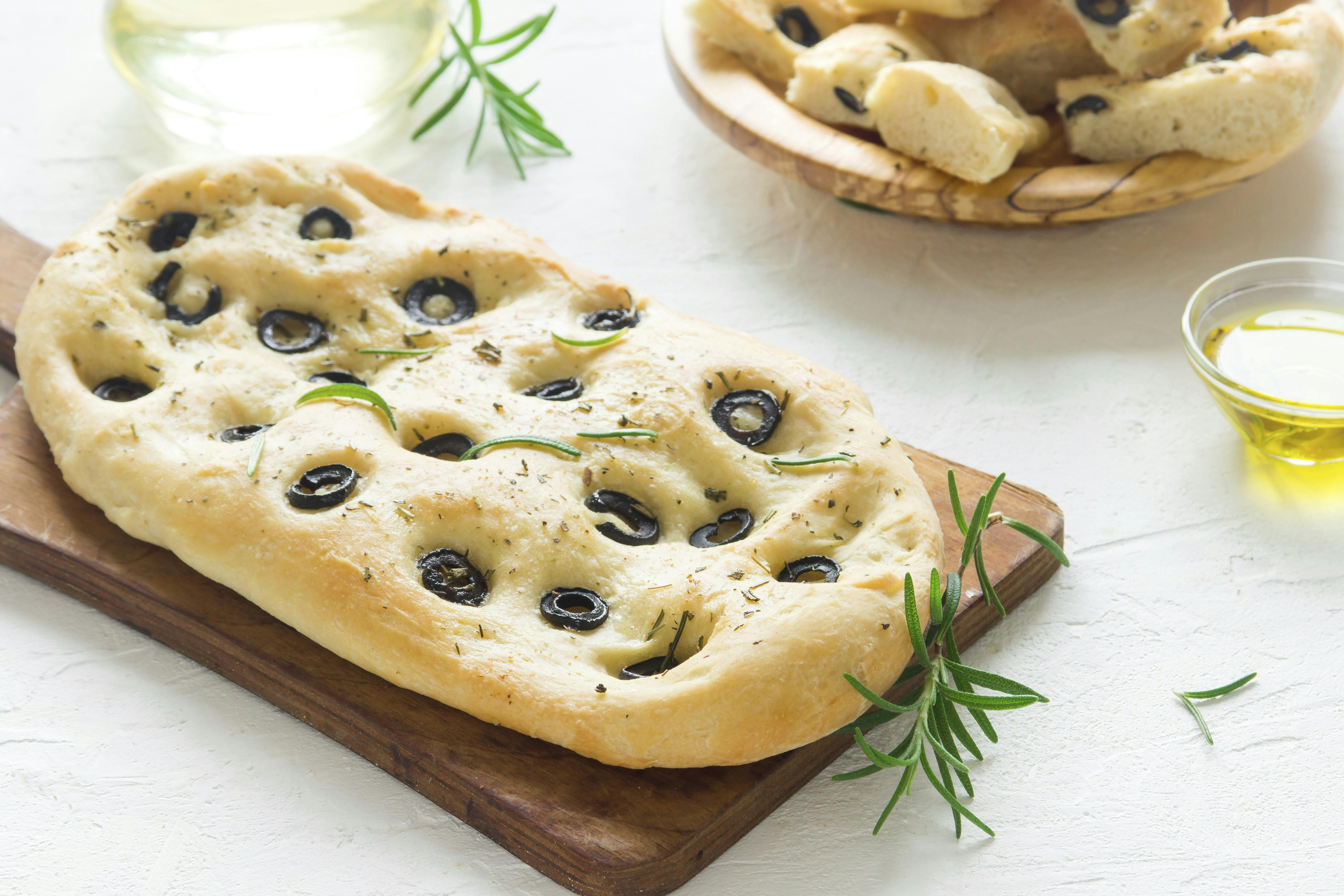 Traditional Italian Focaccia with  black olives and rosemary - homemade flat bread focaccia