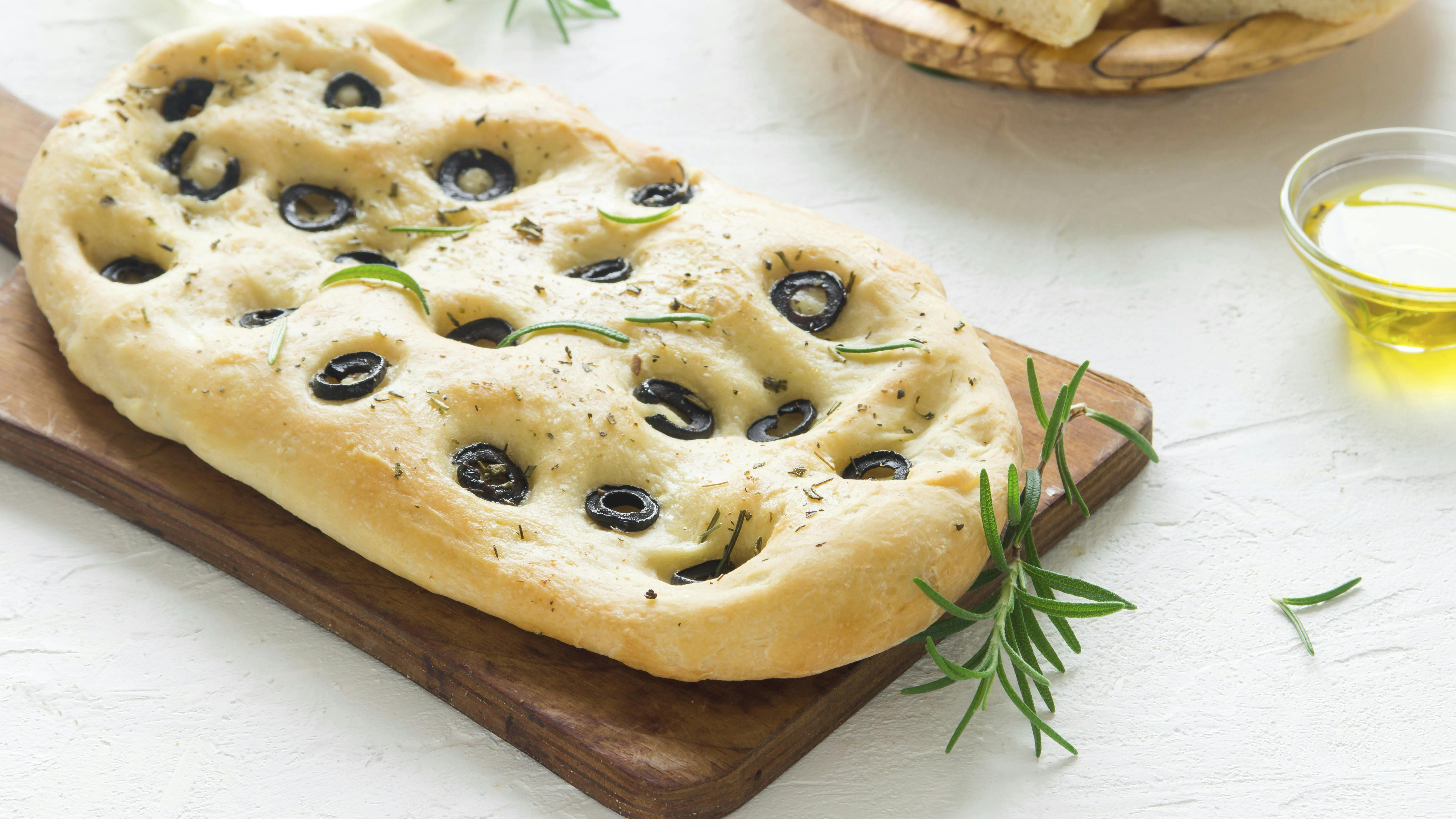 Traditional Italian Focaccia with  black olives and rosemary - homemade flat bread focaccia