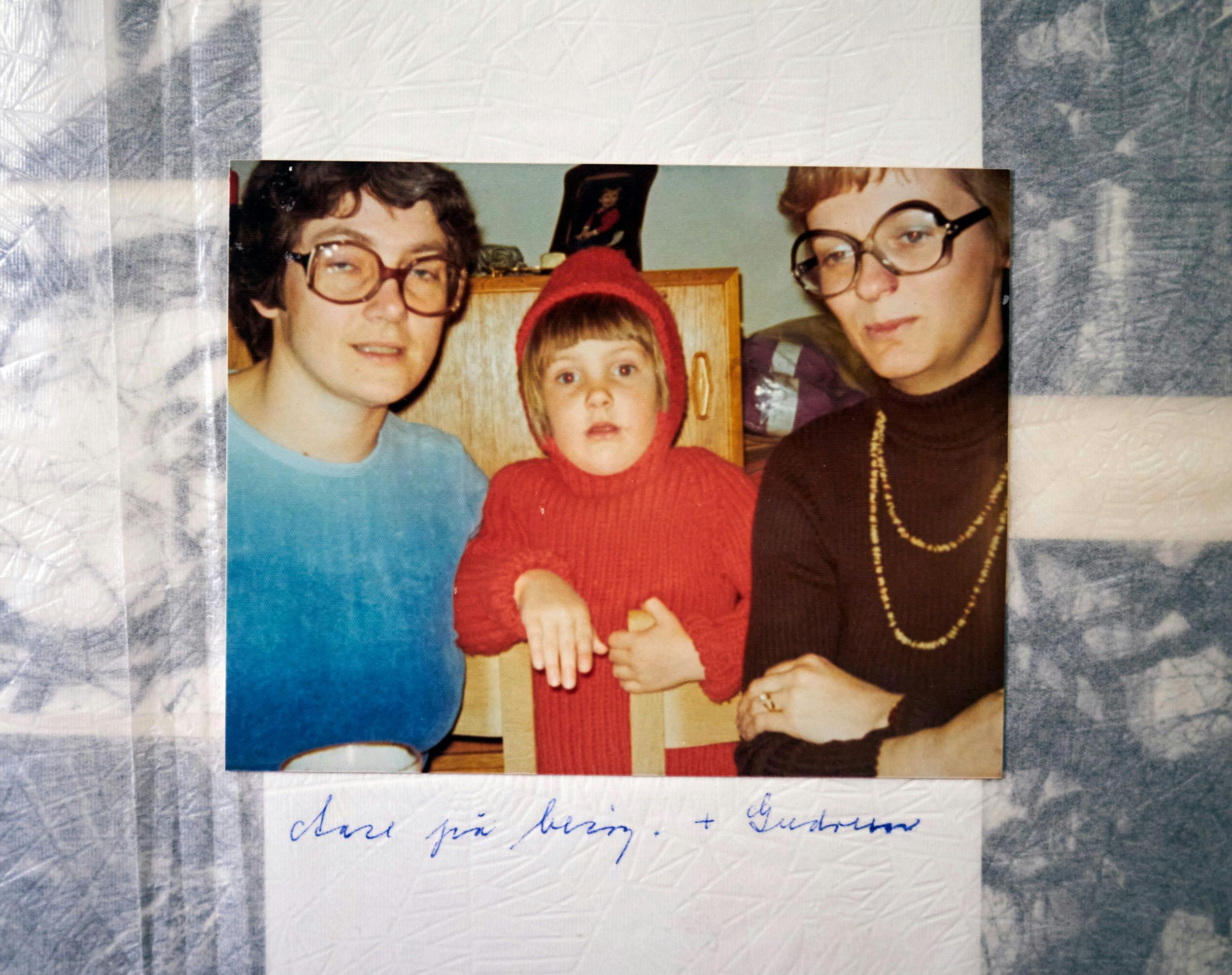 På billedet ses Annes mor, Inge, i blåt med sin veninde Aase, og i midten 5-årige Anne i trøjen af rødt akrylgarn, som moren strikkede til hende.
