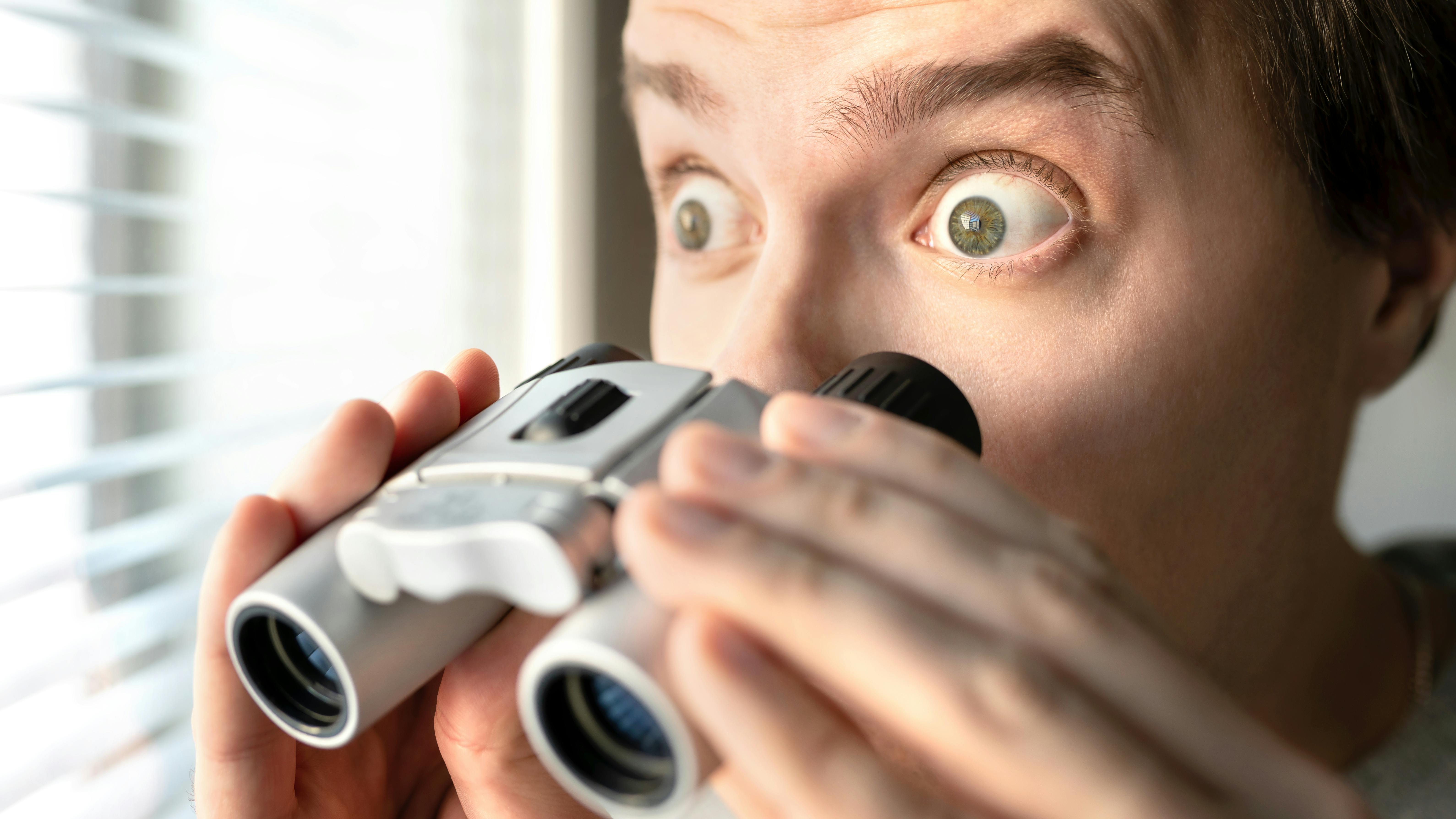 En mand der står med en kikkert.