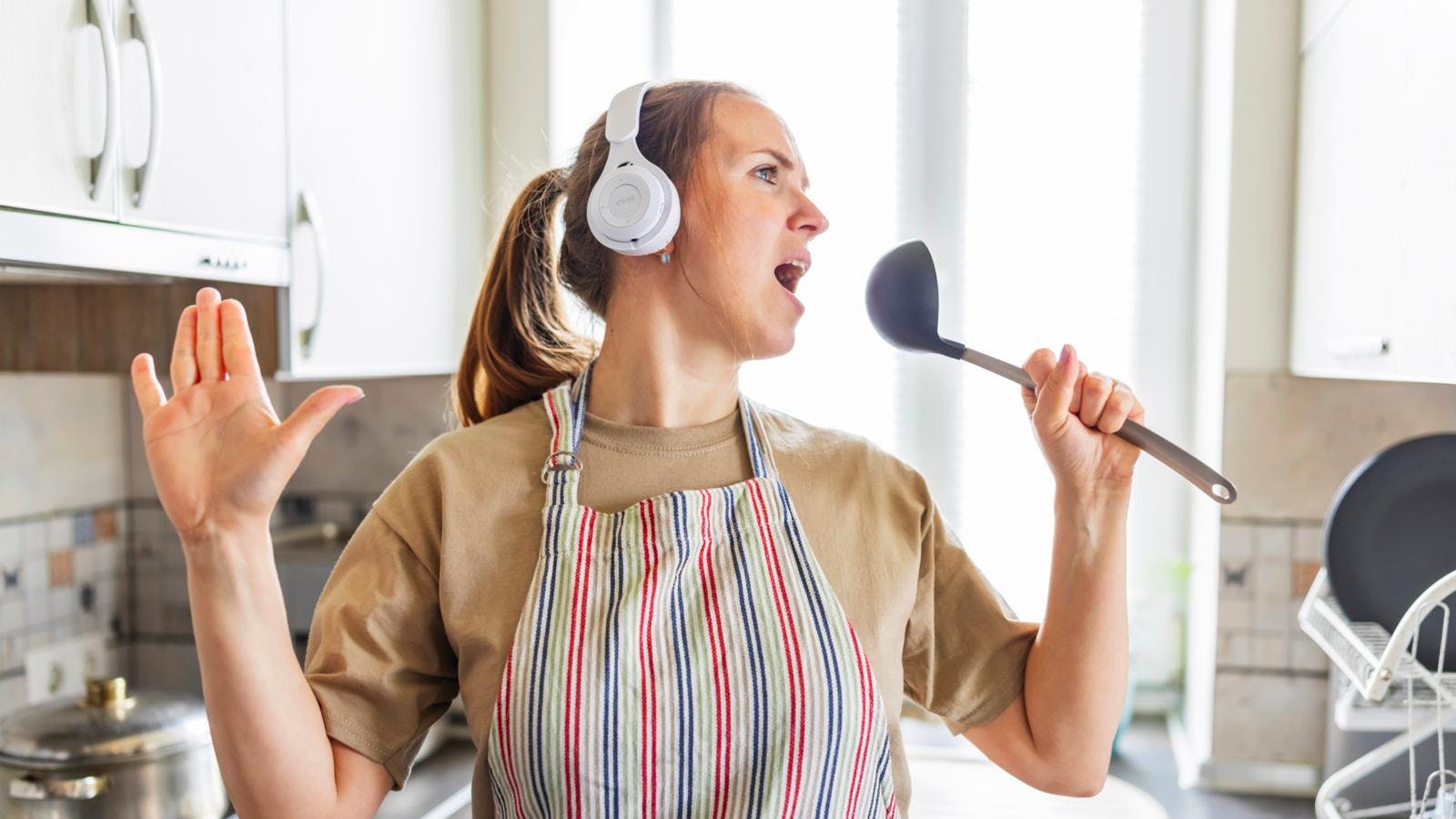 Kvinde der synger i køkkenet
