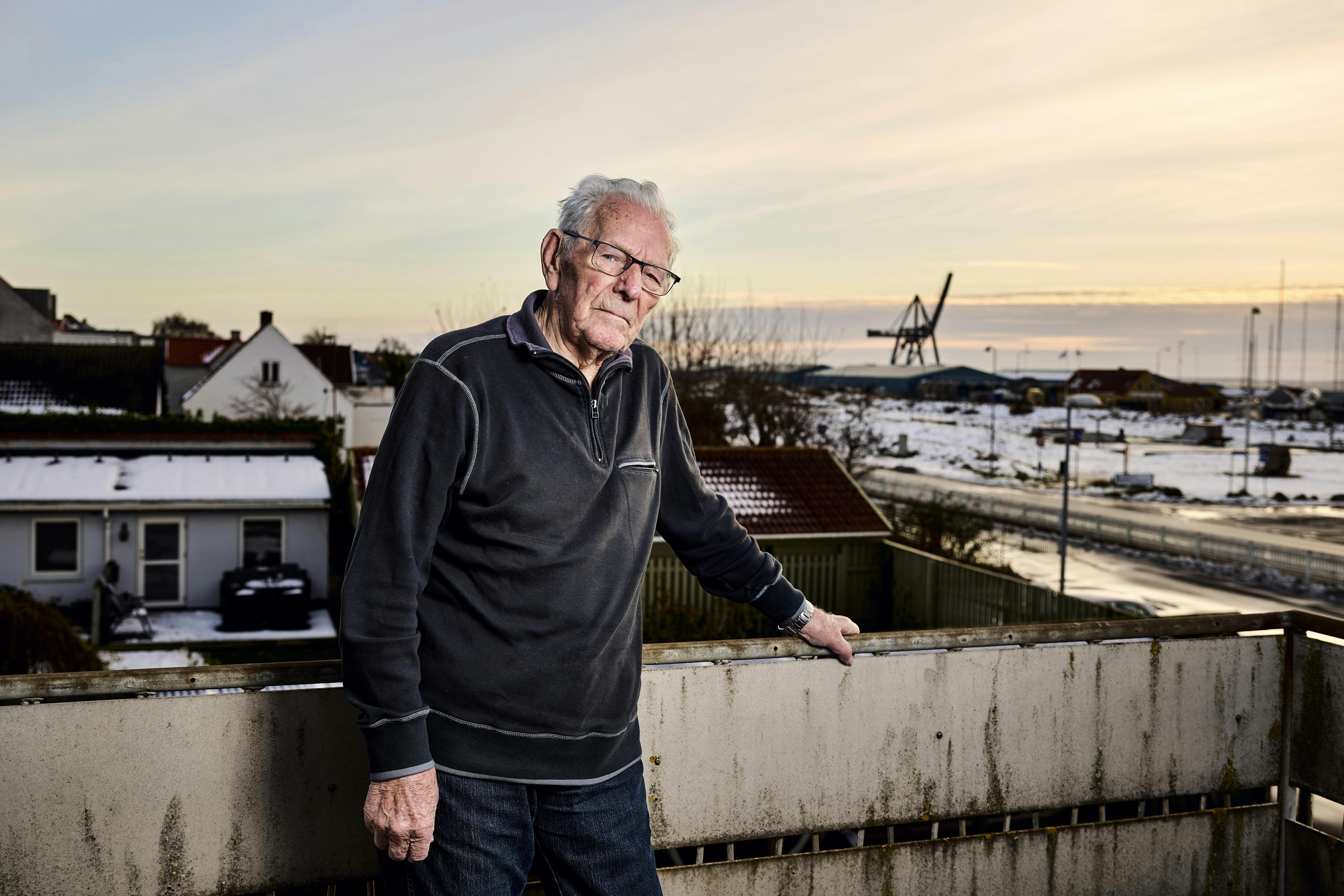 Ejler Borch der står ude på sin altan, hvor man kan se havet i baggrunden.