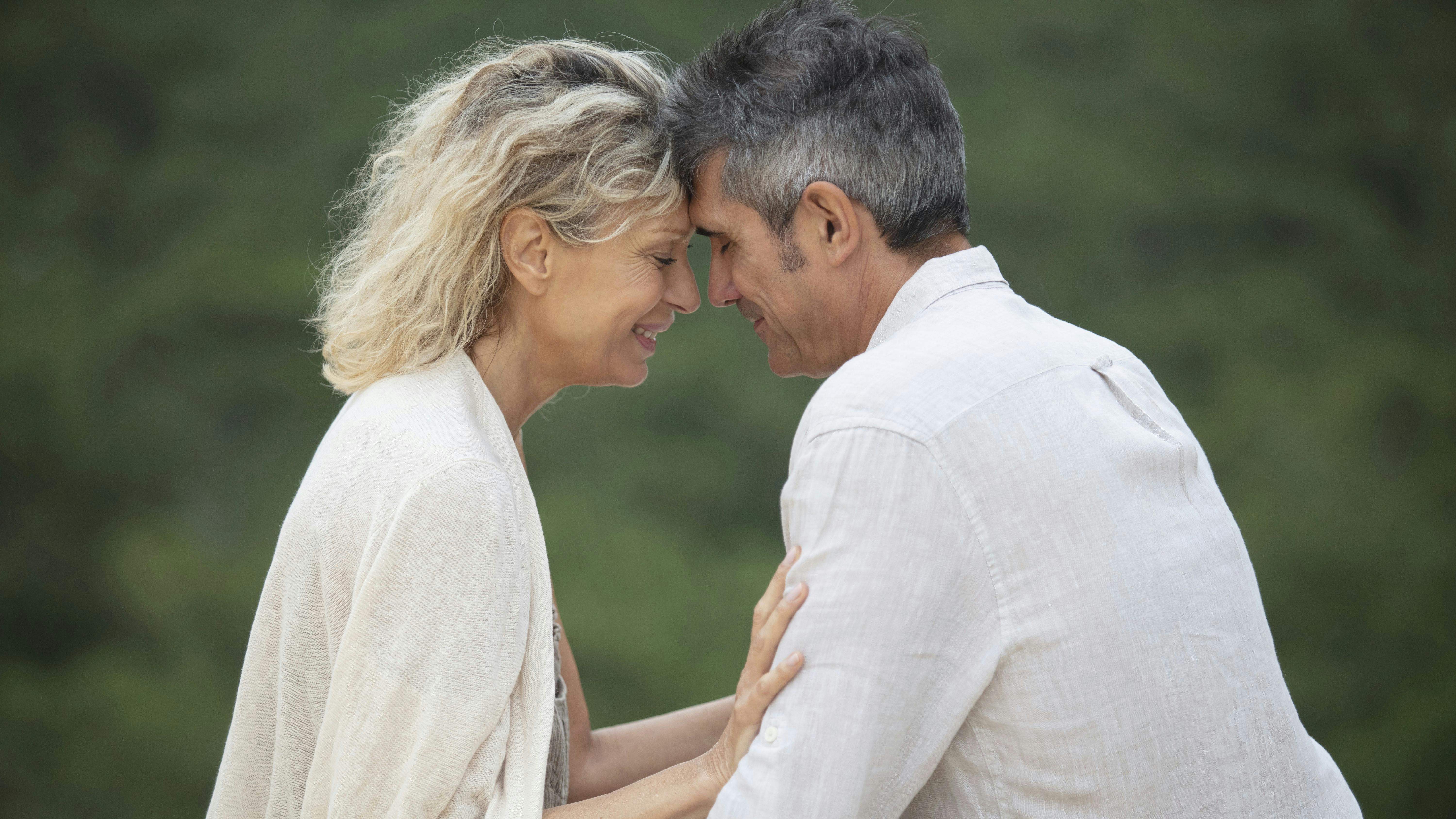 En kvinde og en mand støder panderne kærligt mod hinanden.
