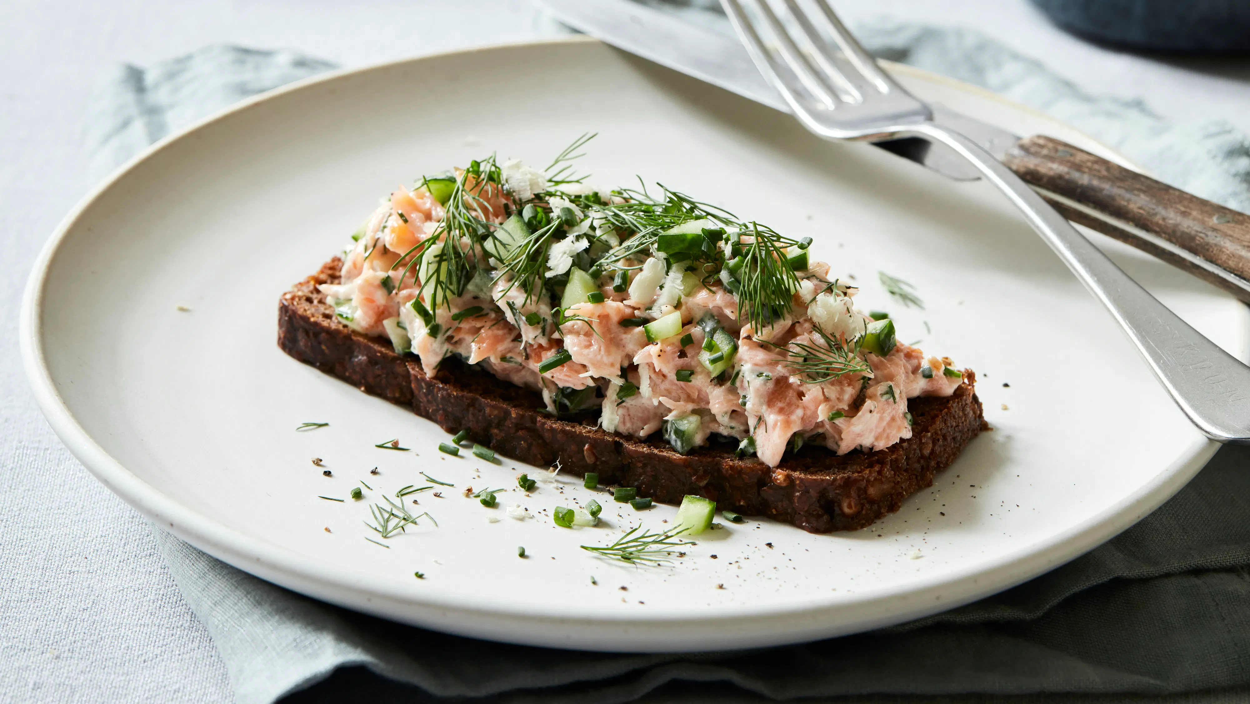 Rugbrød med varmrøget laks, agurk og krydderurter | Familie Journal